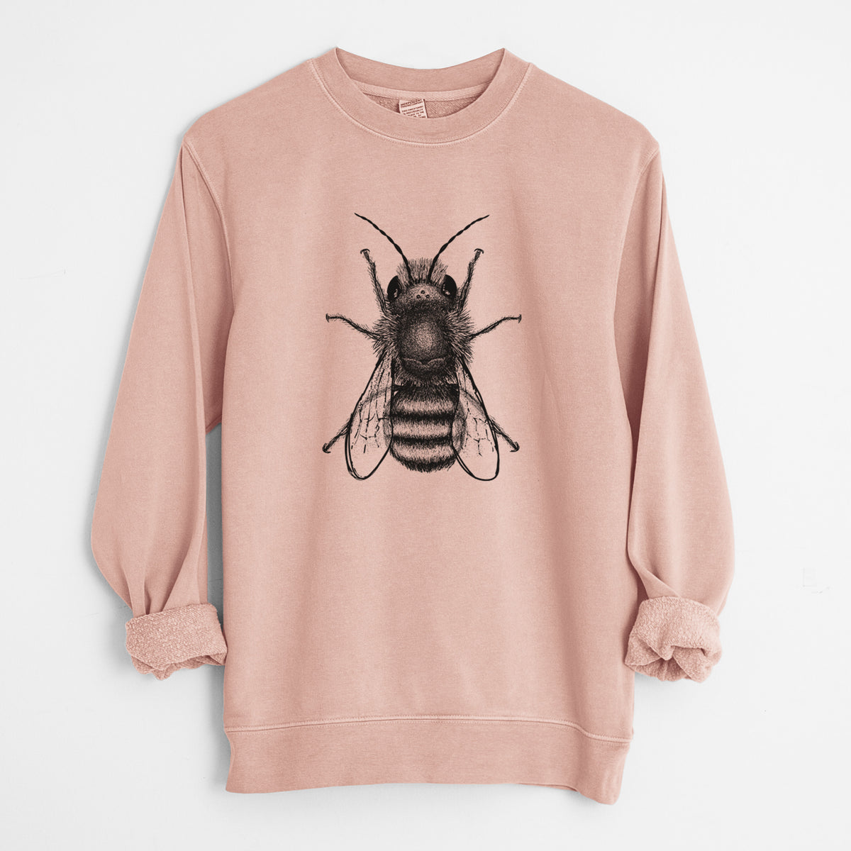 Dusty pink pigment dyed crewneck sweatshirt laid flat with the sleeves rolled, printed with a detailed black ink illustration of a red mason bee with its wings spread, seen from above.