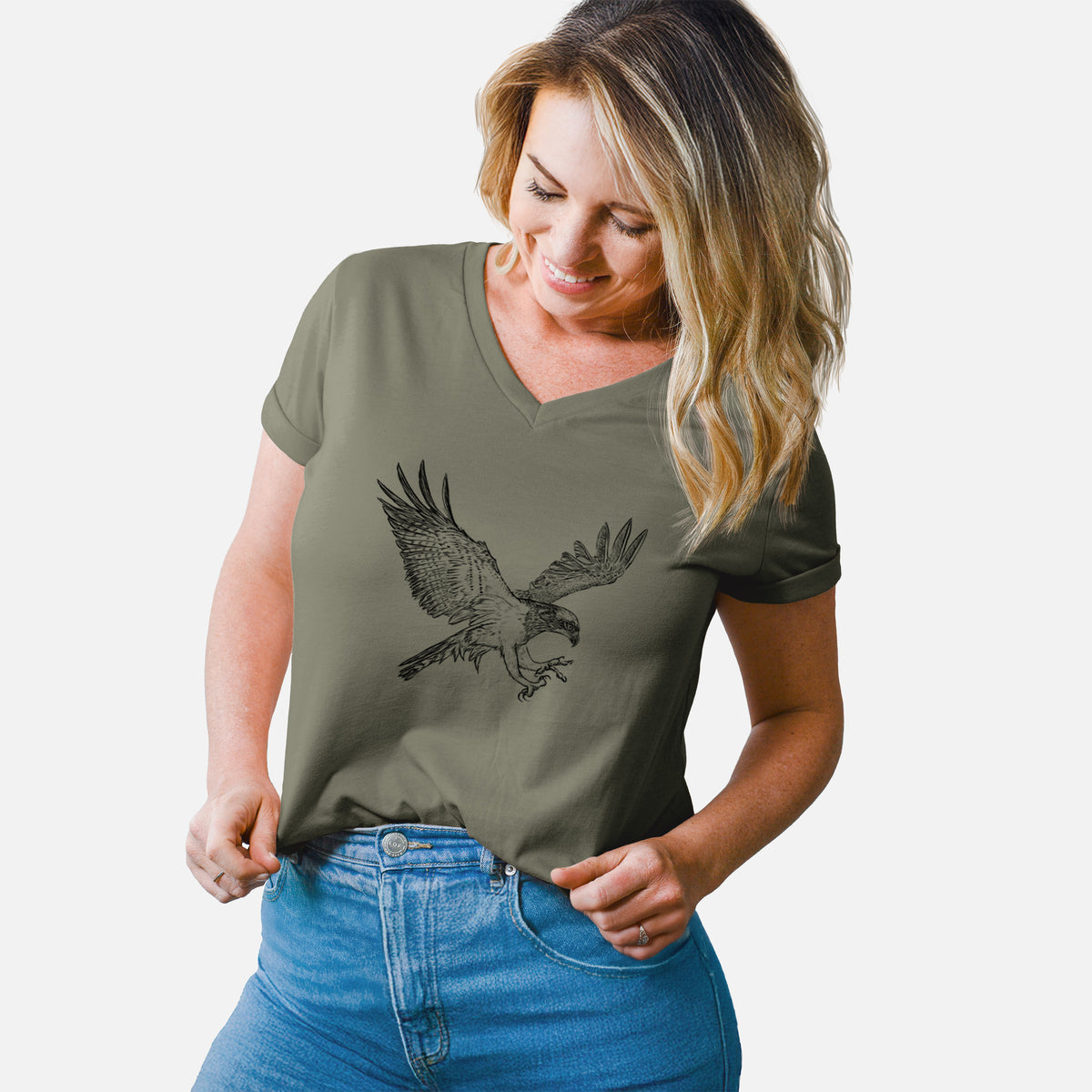 Woman wearing a military green women's relaxed fit cotton V-neck t-shirt printed with a black ink illustration of an osprey in flight with its wings spread.