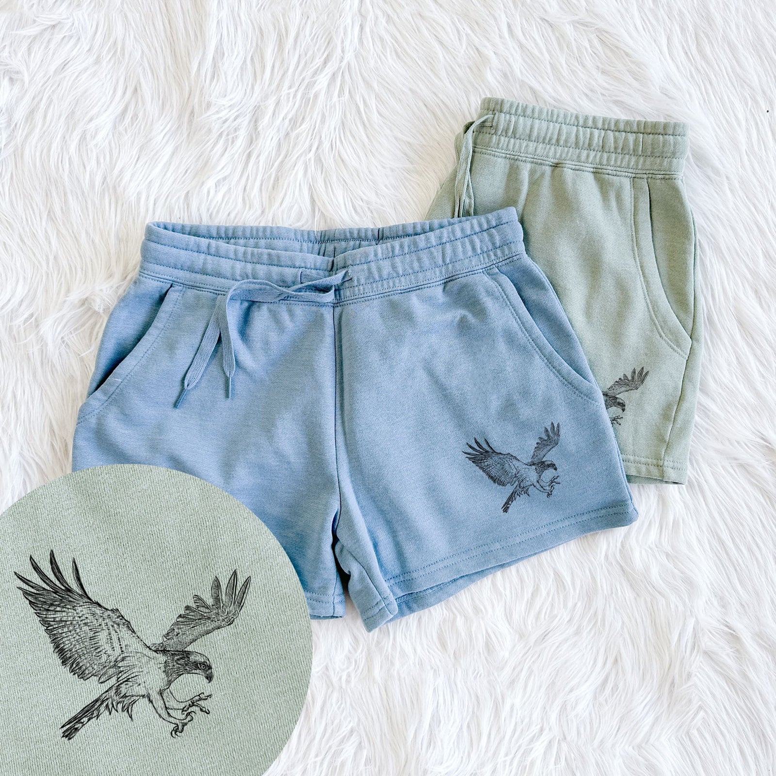 Two pairs of Cali Wave shorts in different colors printed with a black ink illustration of an osprey in flight with its wings spread, with a close-up of the print.