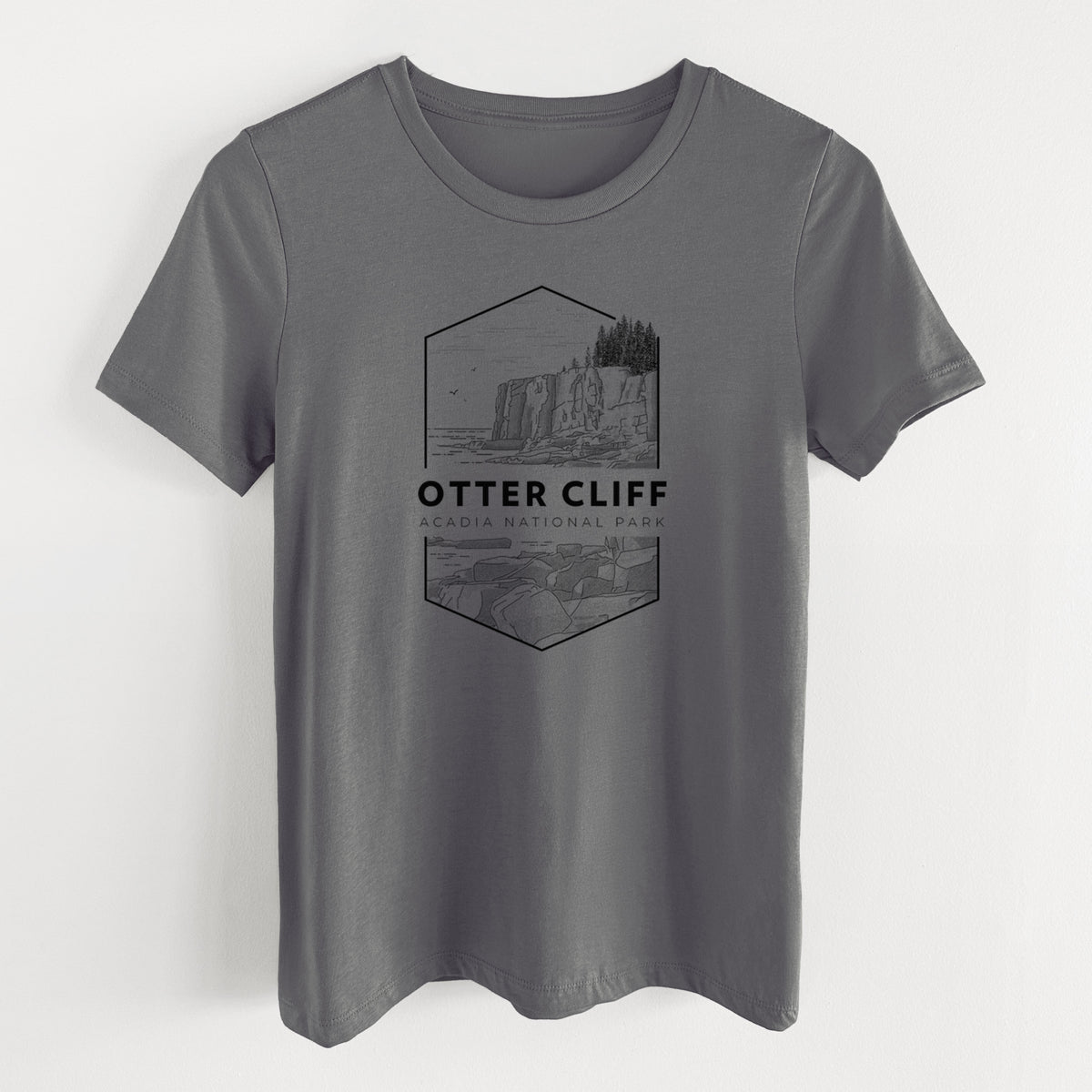 Asphalt women's relaxed fit cotton t-shirt laid flat, printed with a black line art badge of Otter Cliff above the ocean, with the words Otter Cliff, Acadia National Park.