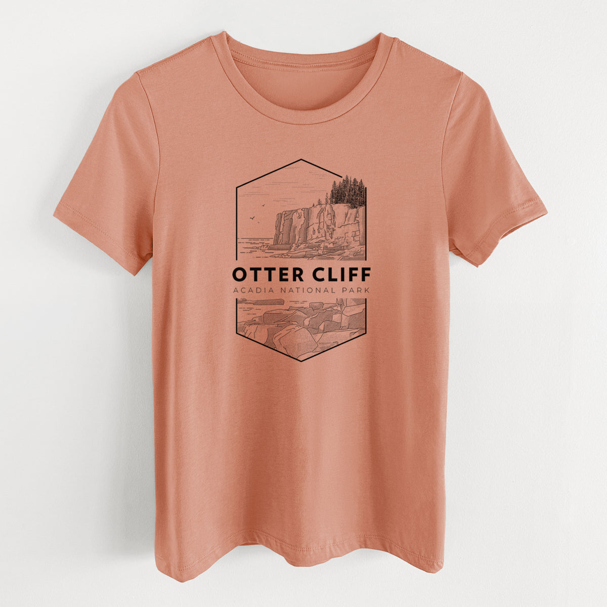 Terracotta orange women's relaxed fit cotton t-shirt laid flat, printed with a black line art badge of Otter Cliff above the ocean, with the words Otter Cliff, Acadia National Park.