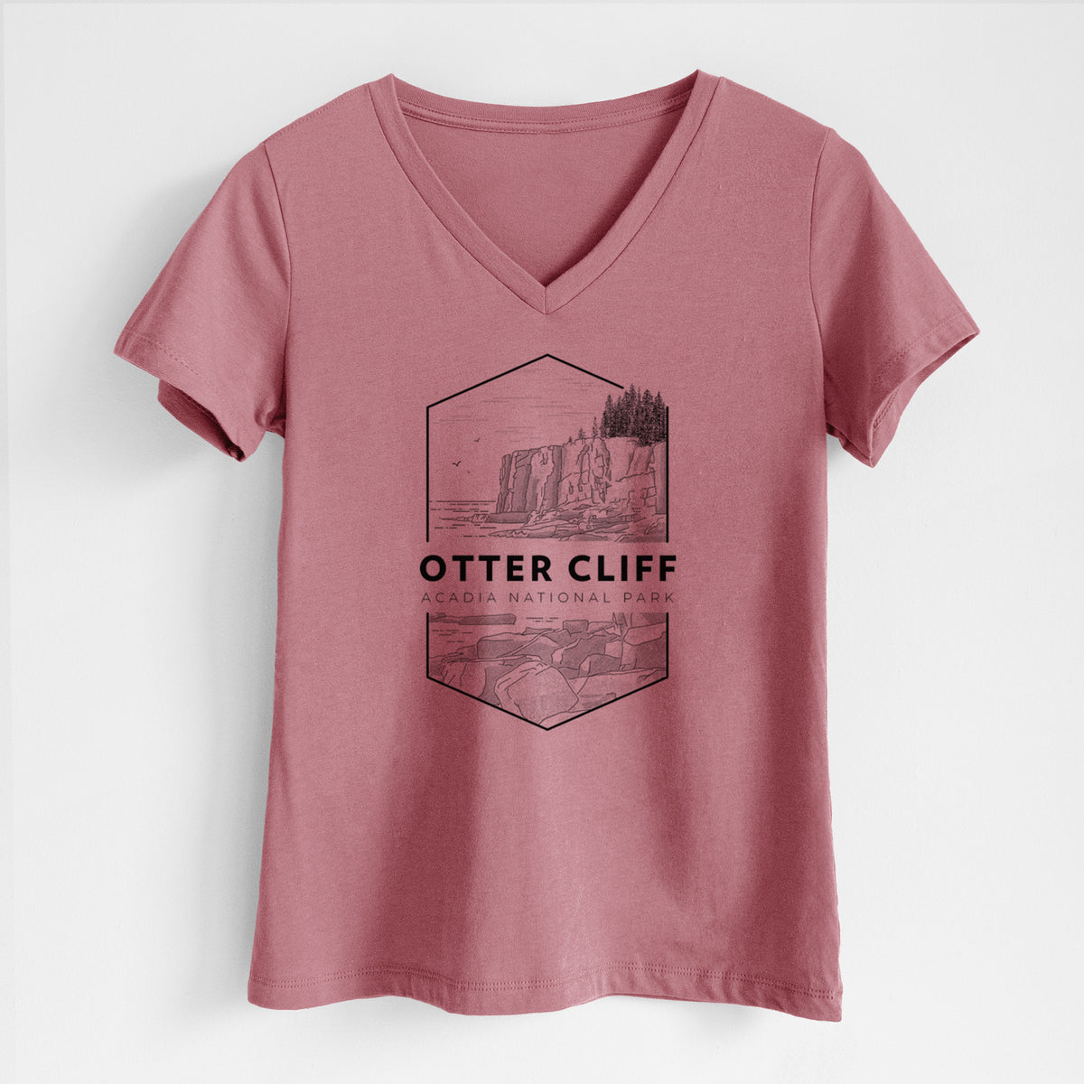 Mauve pink women's relaxed fit cotton V-neck t-shirt laid flat, printed with a black line art badge of Otter Cliff above the ocean, with the words Otter Cliff, Acadia National Park.