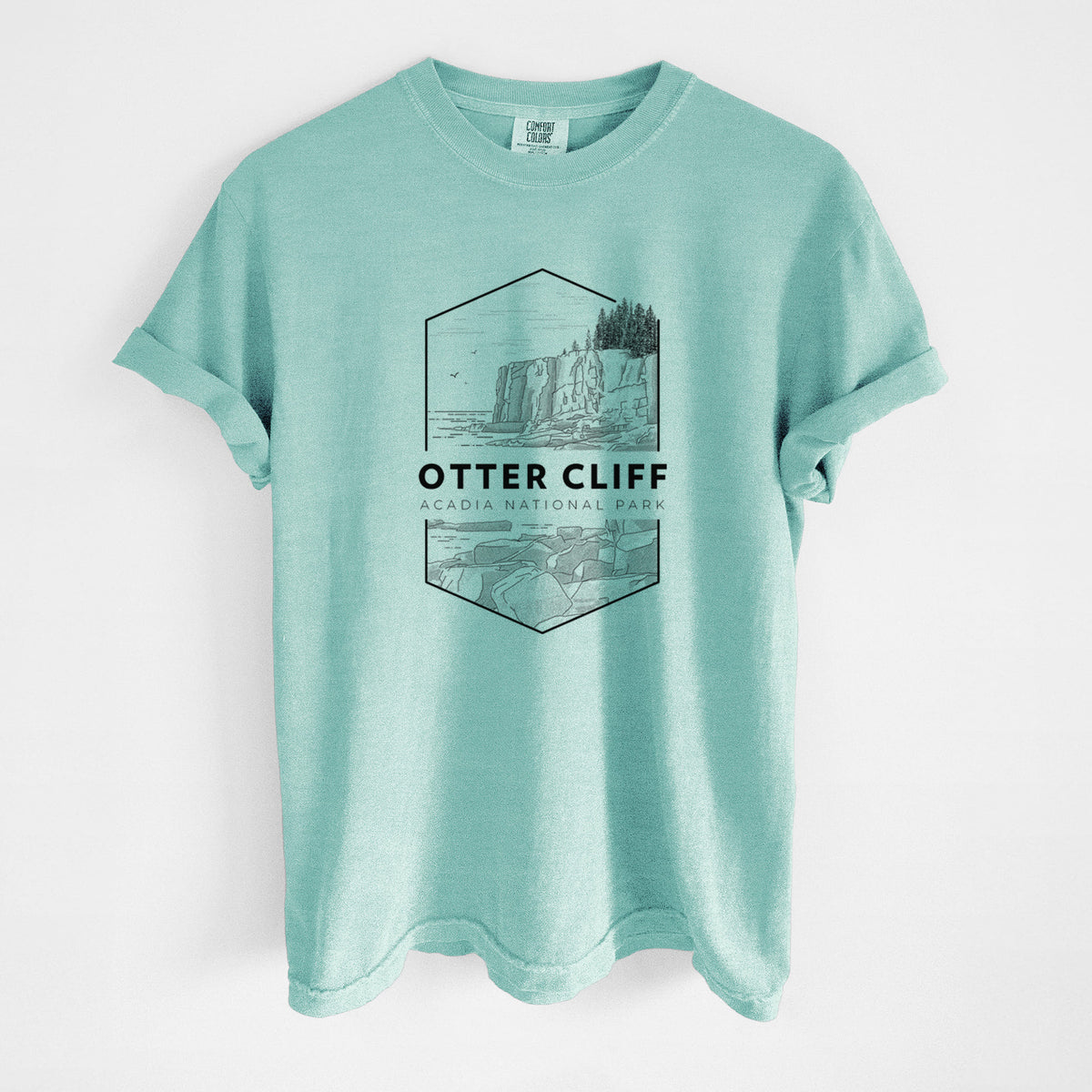 Chalky mint Comfort Colors t-shirt laid flat, printed with a black line art badge of Otter Cliff above the ocean, with the words Otter Cliff, Acadia National Park.