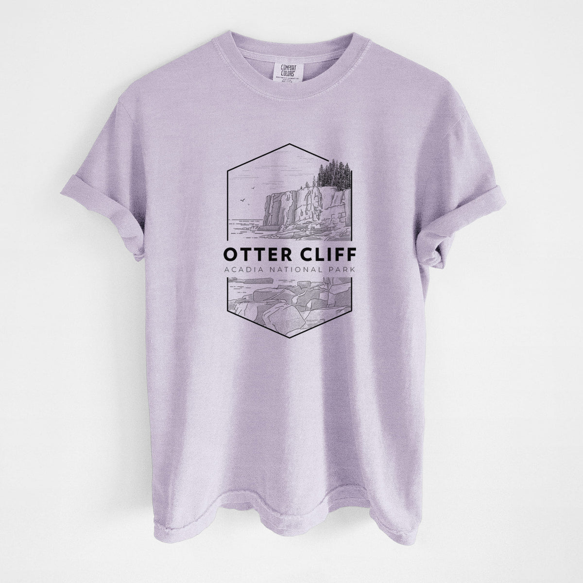 Orchid purple Comfort Colors t-shirt laid flat, printed with a black line art badge of Otter Cliff above the ocean, with the words Otter Cliff, Acadia National Park.