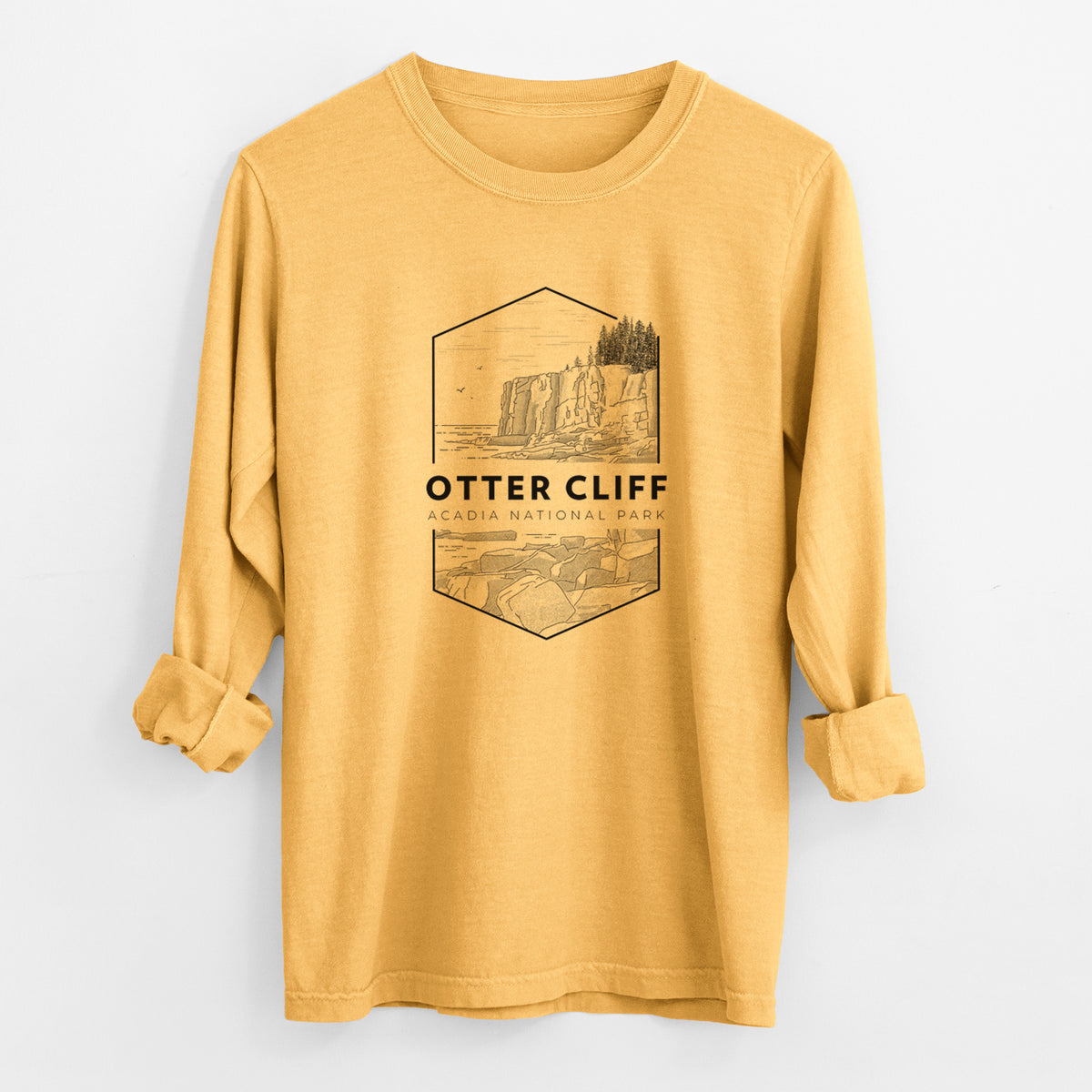 Golden wheat yellow Comfort Colors long sleeve shirt laid flat with the cuffs rolled, printed with a black line art badge of Otter Cliff above the ocean, with the words Otter Cliff, Acadia National Park.