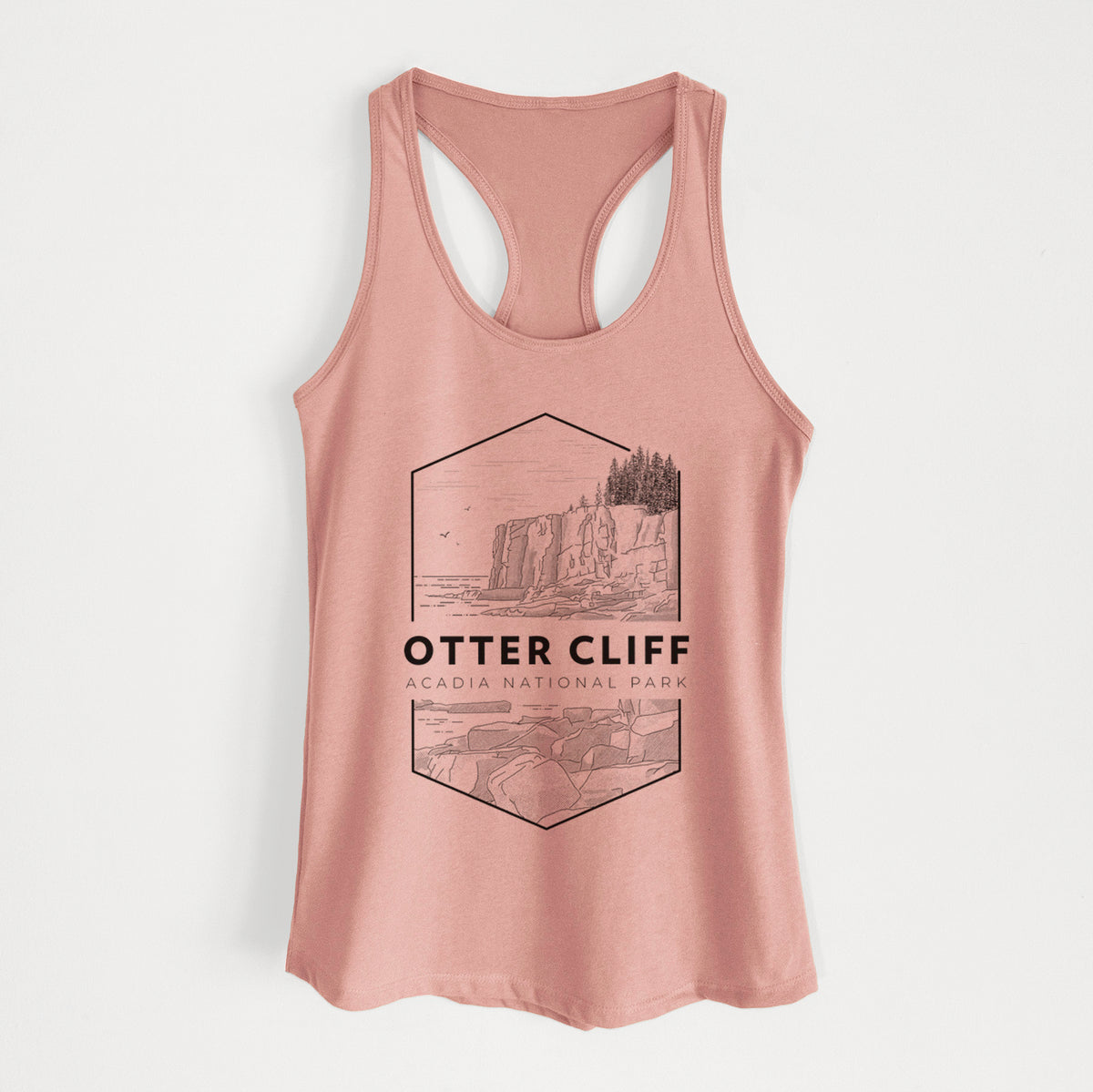 Desert pink women's racerback tank top laid flat, printed with a black line art badge of Otter Cliff above the ocean, with the words Otter Cliff, Acadia National Park.