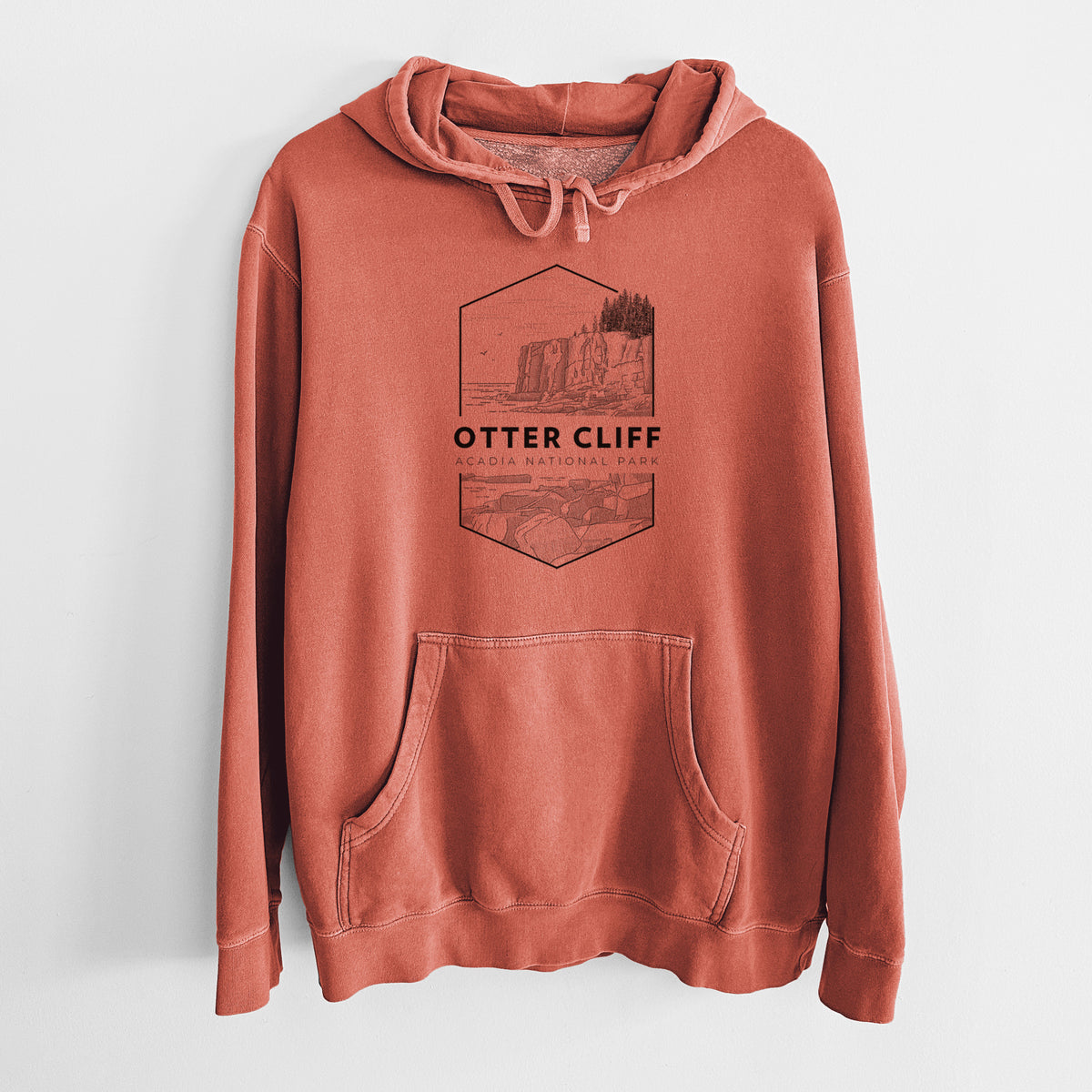 Amber orange pigment dyed hoodie laid flat, printed with a black line art badge of Otter Cliff above the ocean, with the words Otter Cliff, Acadia National Park.