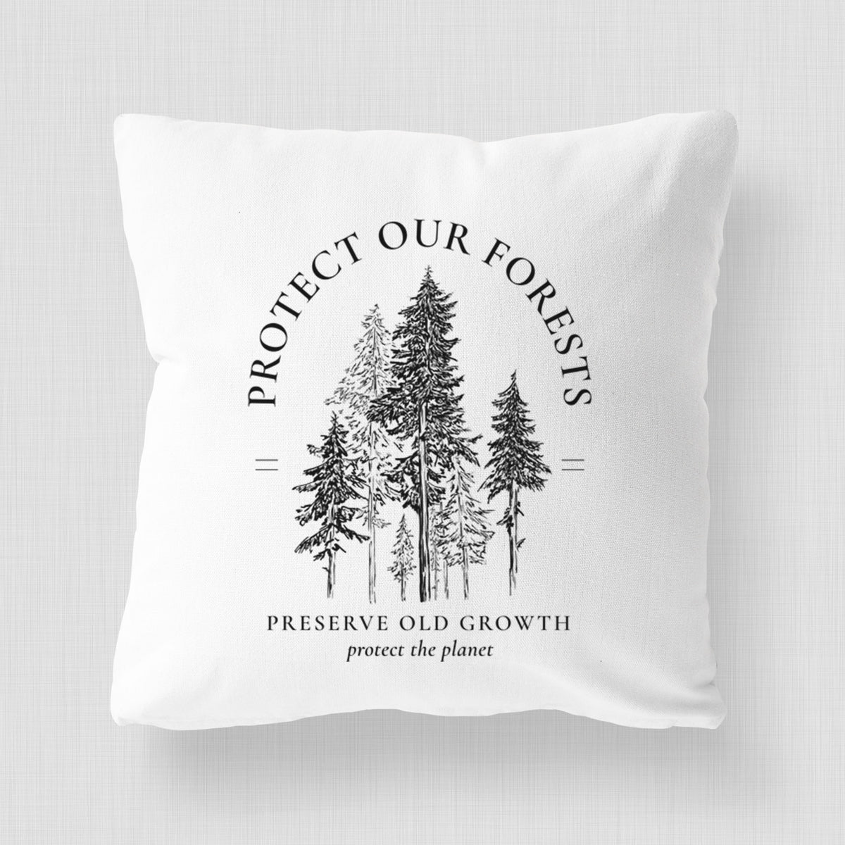 White pillow cover printed with a black ink illustration of a stand of tall pine trees, framed by the words Protect Our Forests, Preserve Old Growth.