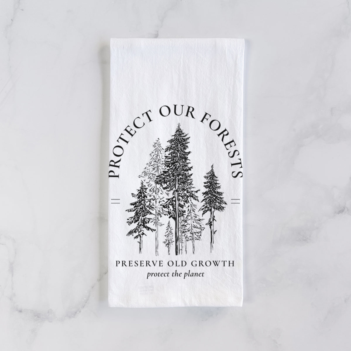 White cotton tea towel laid flat on marble, printed with a black ink illustration of a stand of tall pine trees, framed by the words Protect Our Forests, Preserve Old Growth.