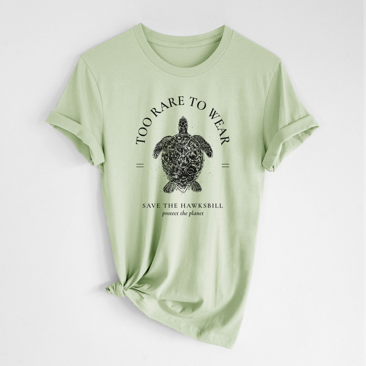 Spring green lightweight cotton t-shirt laid flat with the sleeves rolled, printed with a black ink hawksbill sea turtle framed by the words Too Rare to Wear, Save the Hawksbill.