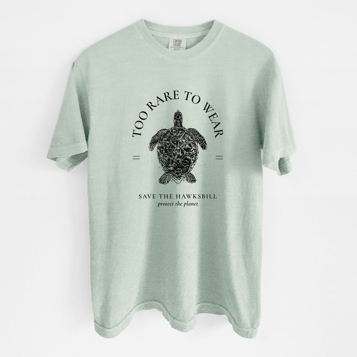 Bay green Comfort Colors t-shirt laid flat, printed with a black ink hawksbill sea turtle framed by the words Too Rare to Wear, Save the Hawksbill.