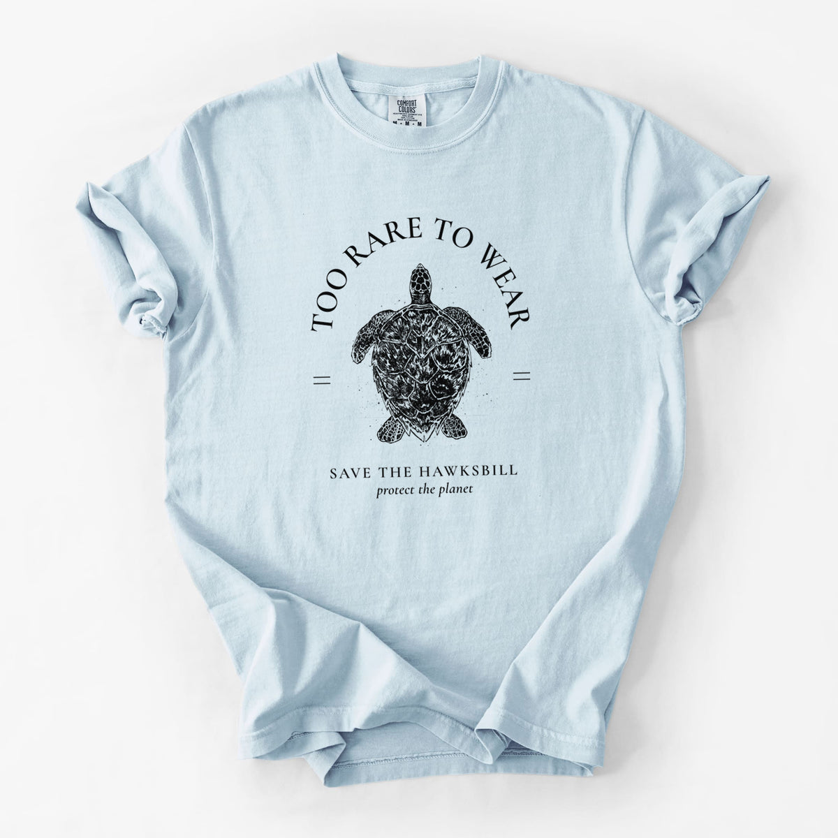Chambray blue Comfort Colors t-shirt laid flat, printed with a black ink hawksbill sea turtle framed by the words Too Rare to Wear, Save the Hawksbill.