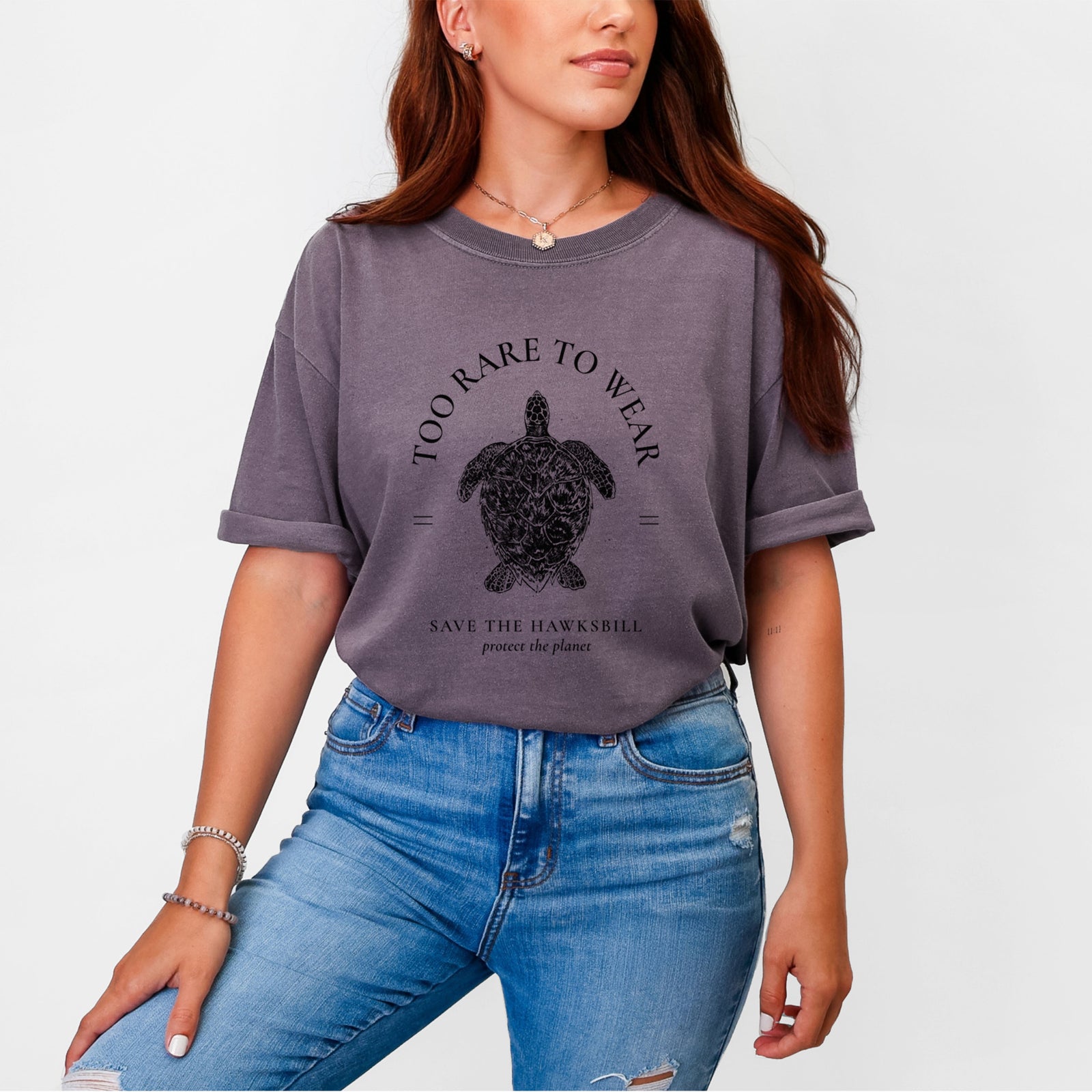 Blue jean Comfort Colors t-shirt laid flat, printed with a black ink hawksbill sea turtle framed by the words Too Rare to Wear, Save the Hawksbill.