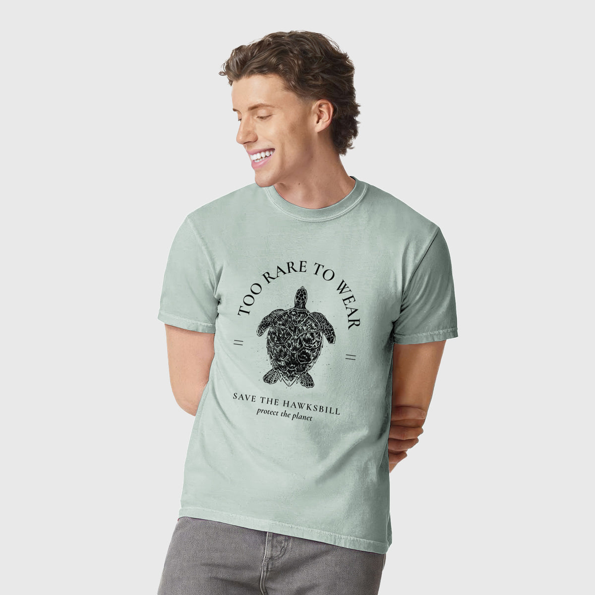 Man wearing a Comfort Colors t-shirt printed with a black ink hawksbill sea turtle framed by the words Too Rare to Wear, Save the Hawksbill.