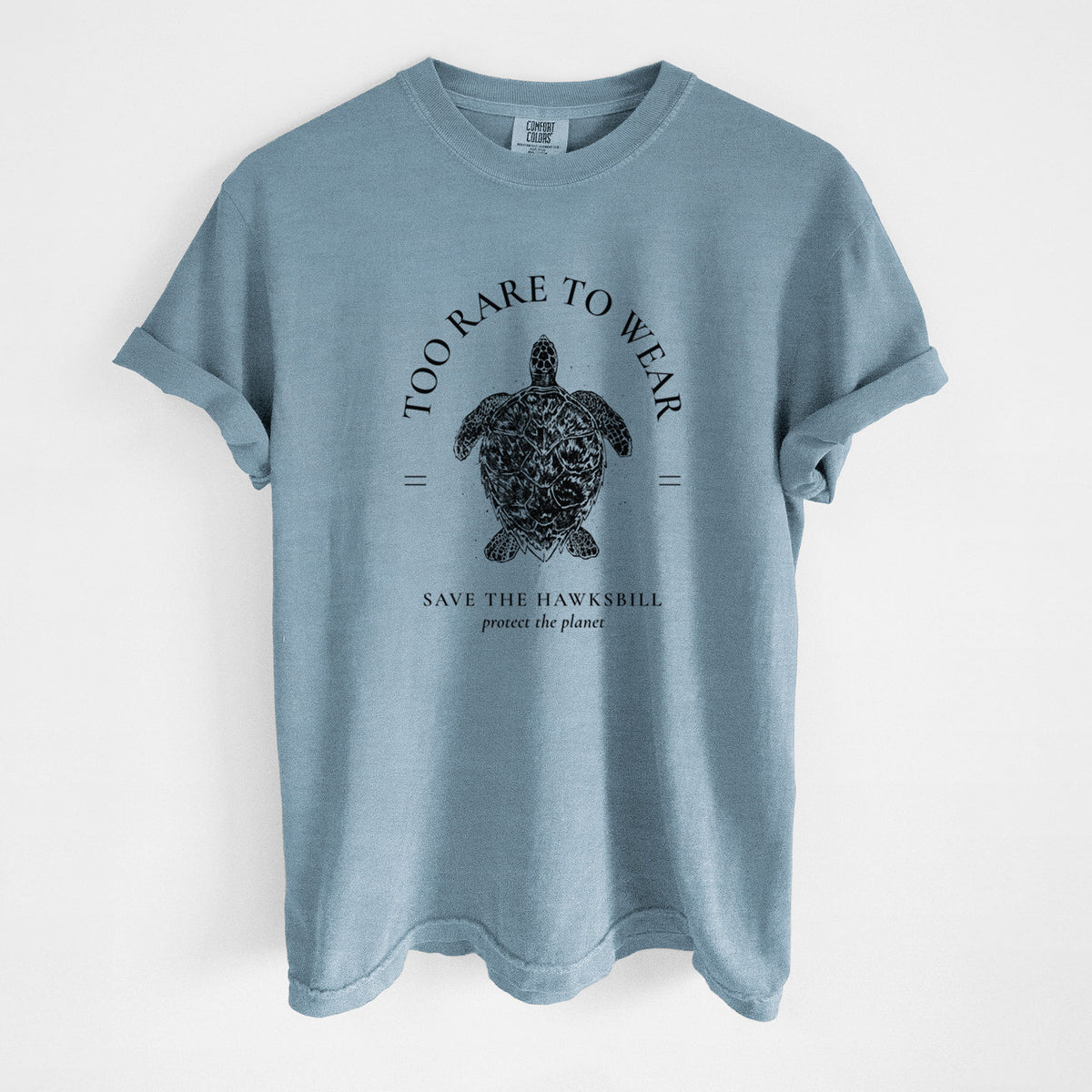Steel blue Comfort Colors t-shirt laid flat, printed with a black ink hawksbill sea turtle framed by the words Too Rare to Wear, Save the Hawksbill.