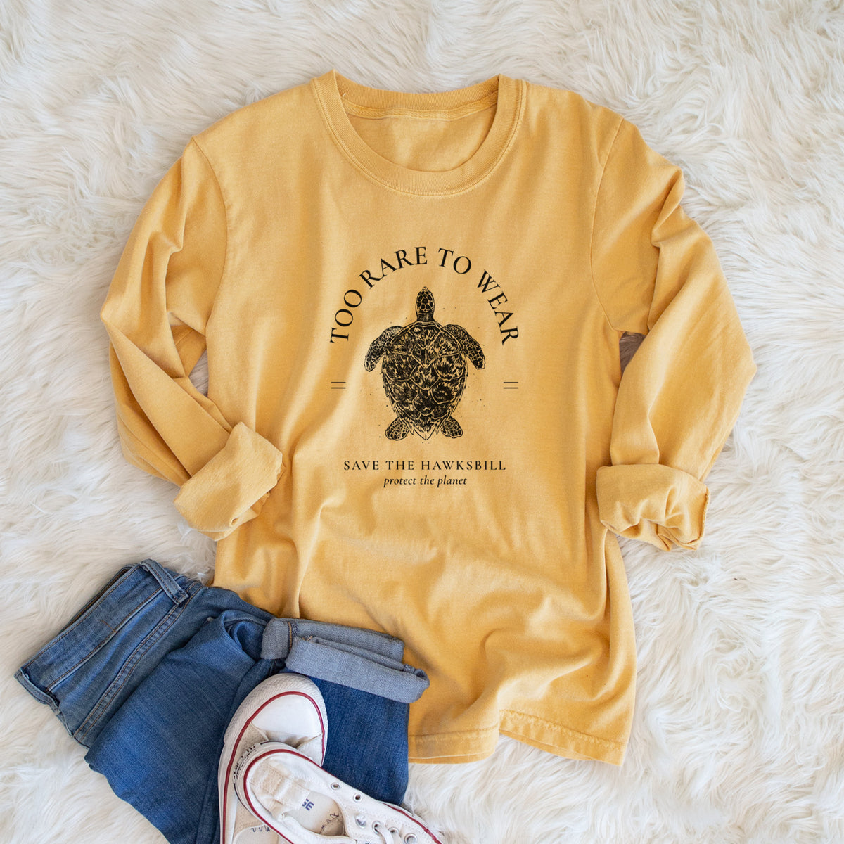 Golden wheat yellow Comfort Colors long sleeve shirt printed with a black ink hawksbill sea turtle framed by the words Too Rare to Wear, Save the Hawksbill, shown in a lifestyle photo.
