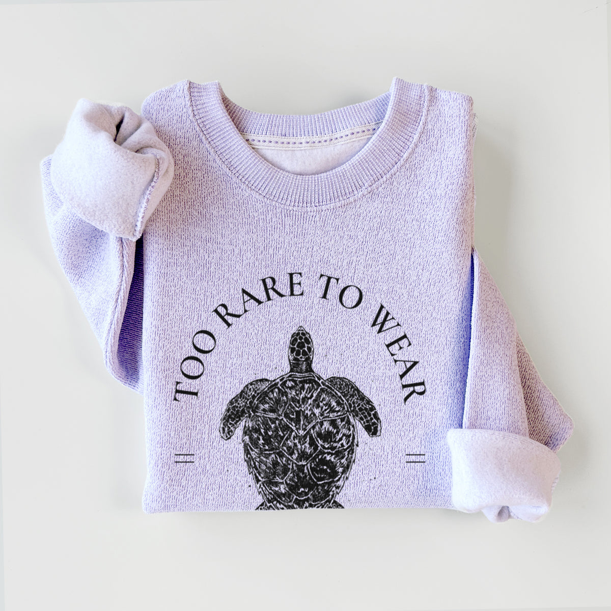Ice purple knit sweatshirt printed with a black ink hawksbill sea turtle framed by the words Too Rare to Wear, Save the Hawksbill, styled flat.