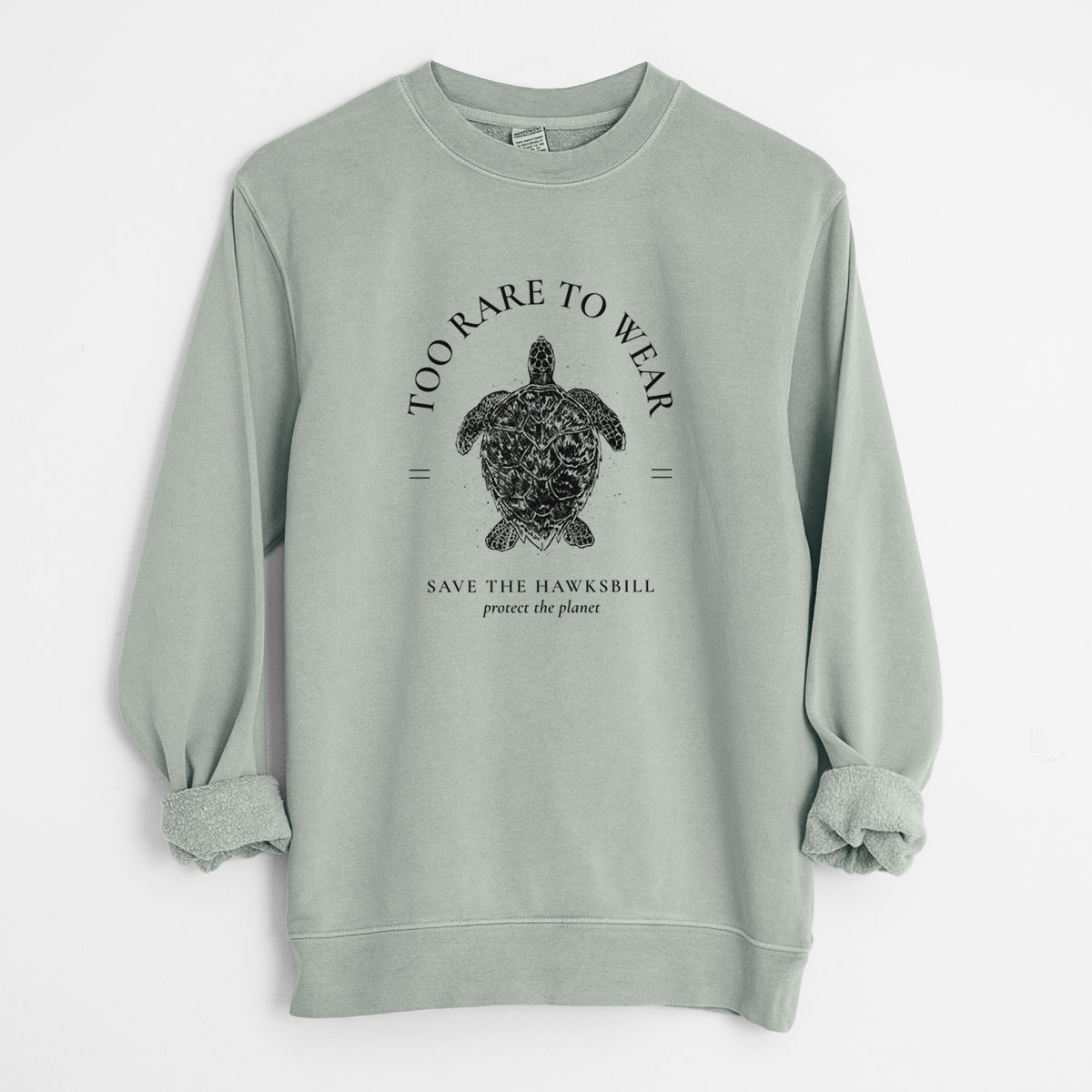 Sage green pigment dyed crewneck sweatshirt laid flat with the sleeves rolled, printed with a black ink hawksbill sea turtle framed by the words Too Rare to Wear, Save the Hawksbill.