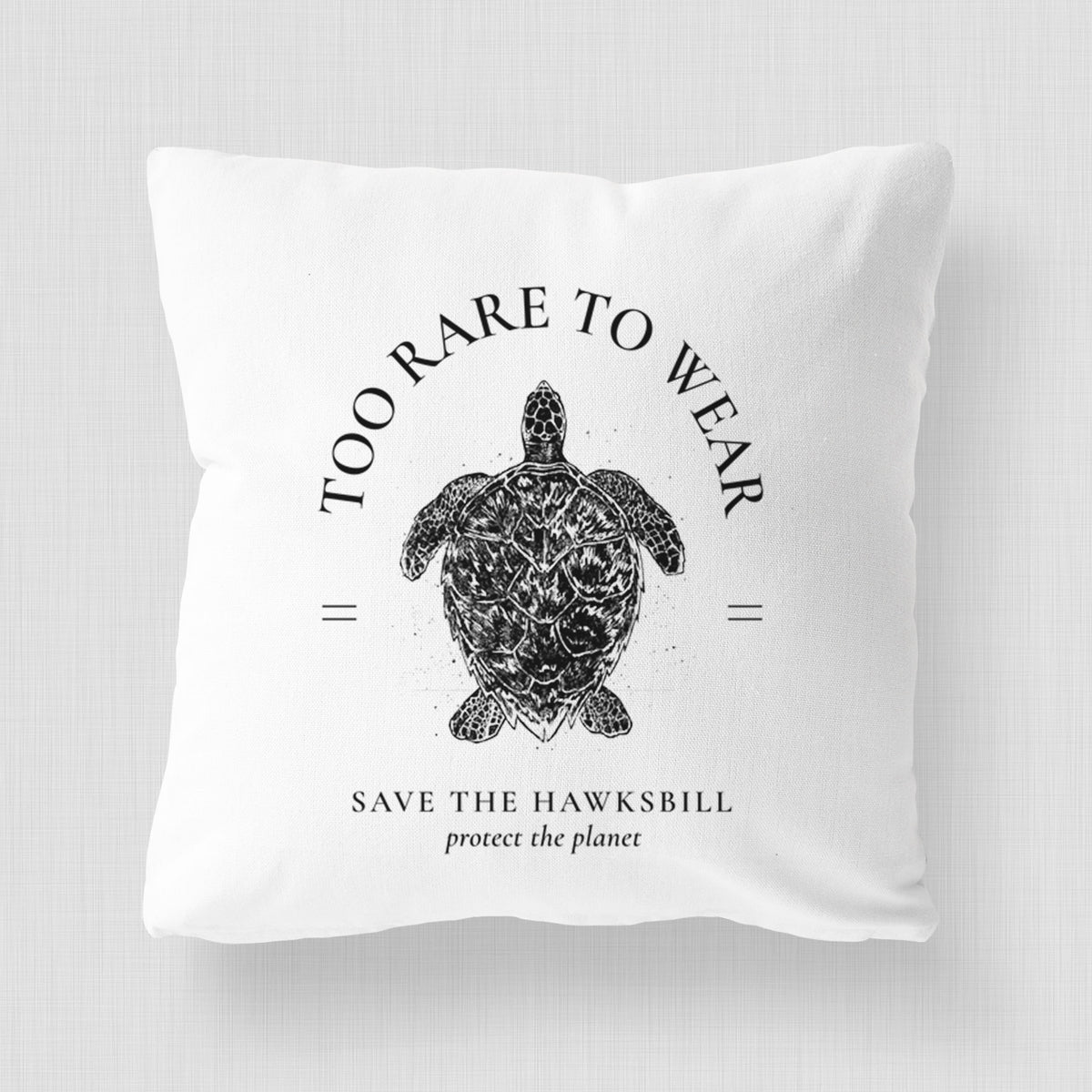 White pillow cover printed with a black ink hawksbill sea turtle framed by the words Too Rare to Wear, Save the Hawksbill.