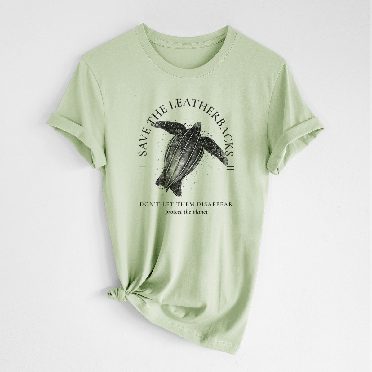 Spring green lightweight cotton t-shirt laid flat with the sleeves rolled, printed with a black ink leatherback sea turtle framed by the words Save the Leatherbacks, Don't Let Them Disappear.
