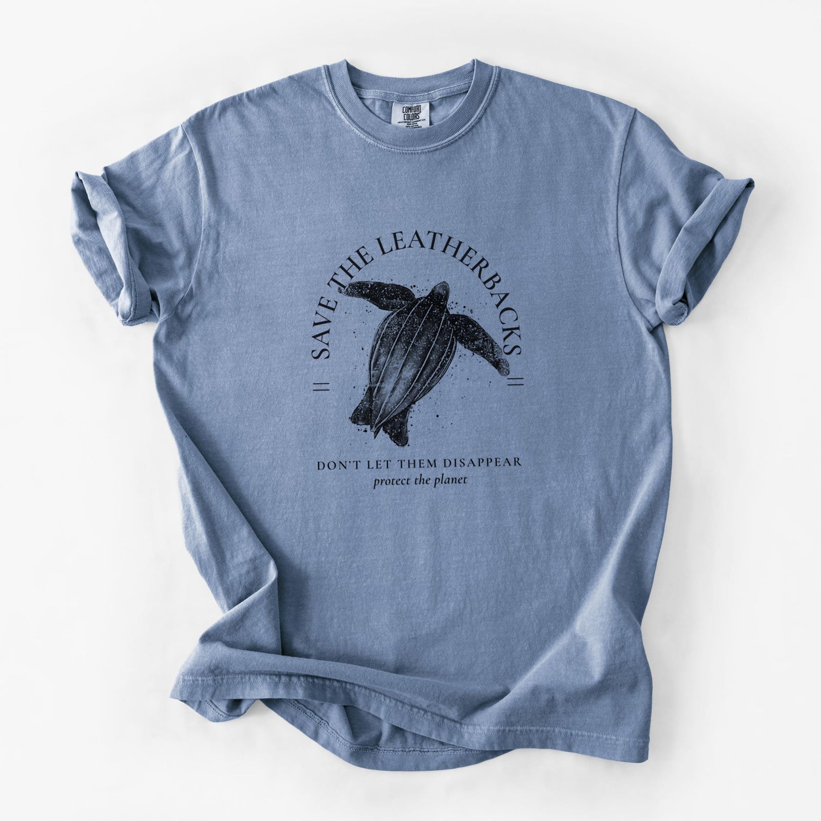 Blue jean Comfort Colors t-shirt laid flat, printed with a black ink leatherback sea turtle framed by the words Save the Leatherbacks, Don't Let Them Disappear.