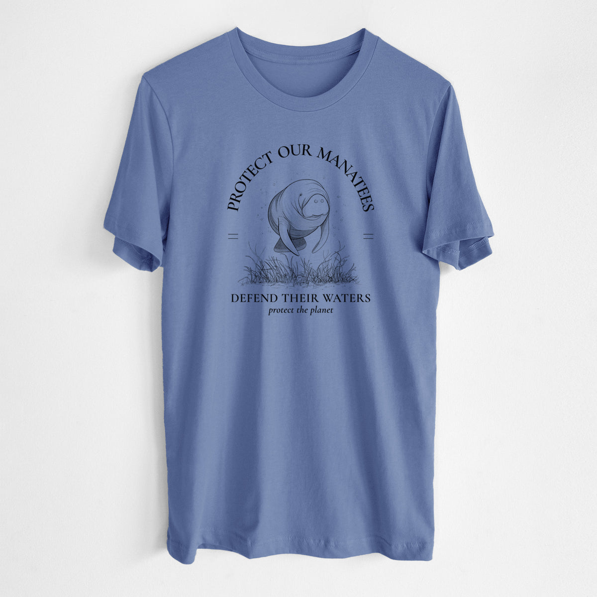 Blue bell lightweight cotton t-shirt laid flat, printed with a black ink illustration of a manatee among seagrass, framed by the words Protect Our Manatees, Defend Their Waters, Protect the Planet.