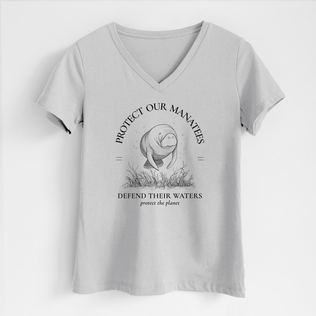Lunar grey women's relaxed fit cotton V-neck t-shirt laid flat, printed with a black ink illustration of a manatee among seagrass, framed by the words Protect Our Manatees, Defend Their Waters, Protect the Planet.
