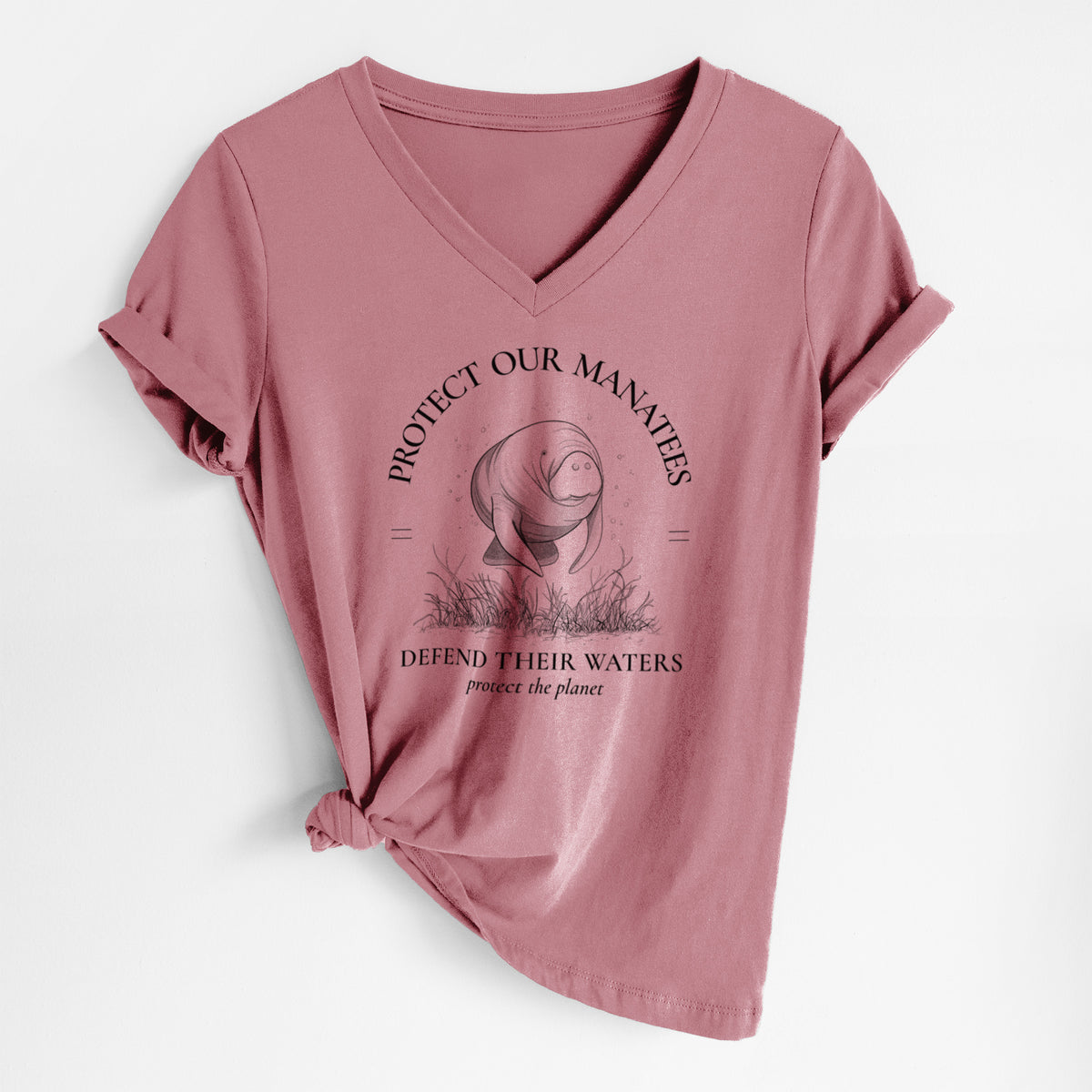 Mauve pink women's relaxed fit cotton V-neck t-shirt laid flat, printed with a black ink illustration of a manatee among seagrass, framed by the words Protect Our Manatees, Defend Their Waters, Protect the Planet.