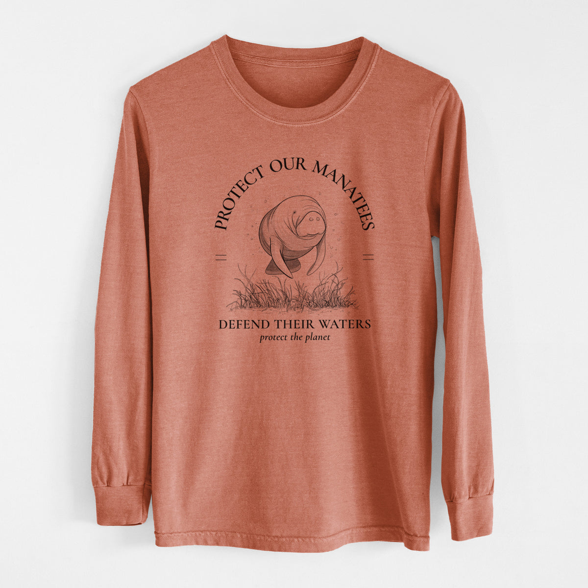 Yam burnt orange Comfort Colors long sleeve shirt laid flat, printed with a black ink illustration of a manatee among seagrass, framed by the words Protect Our Manatees, Defend Their Waters, Protect the Planet.