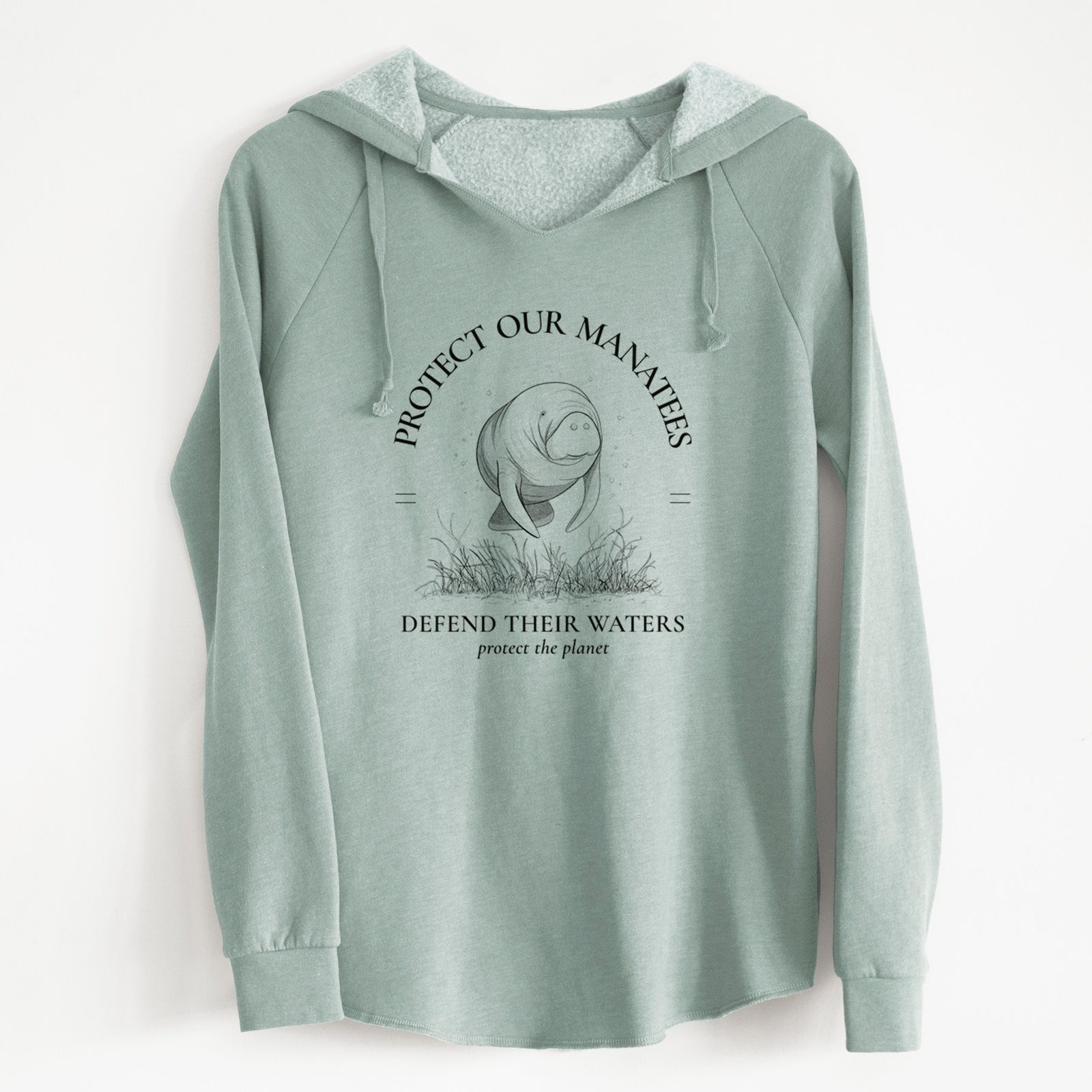 Sage green women's Cali Wave hooded sweatshirt laid flat, printed with a black ink illustration of a manatee among seagrass, framed by the words Protect Our Manatees, Defend Their Waters, Protect the Planet.