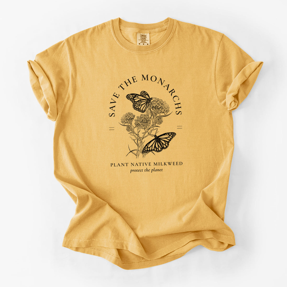 Golden wheat yellow Comfort Colors t-shirt laid flat, printed with black ink monarch butterflies on milkweed flowers, framed by the words Save the Monarchs, Plant Native Milkweed.
