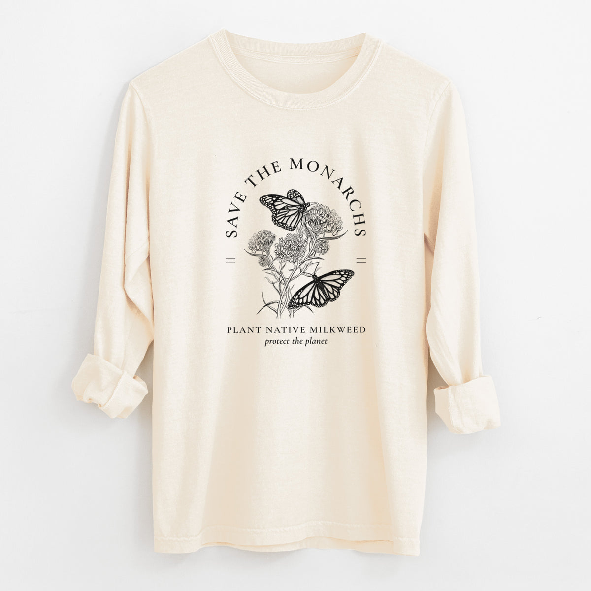Ivory Comfort Colors long sleeve shirt laid flat with the cuffs rolled, printed with black ink monarch butterflies on milkweed flowers, framed by the words Save the Monarchs, Plant Native Milkweed.