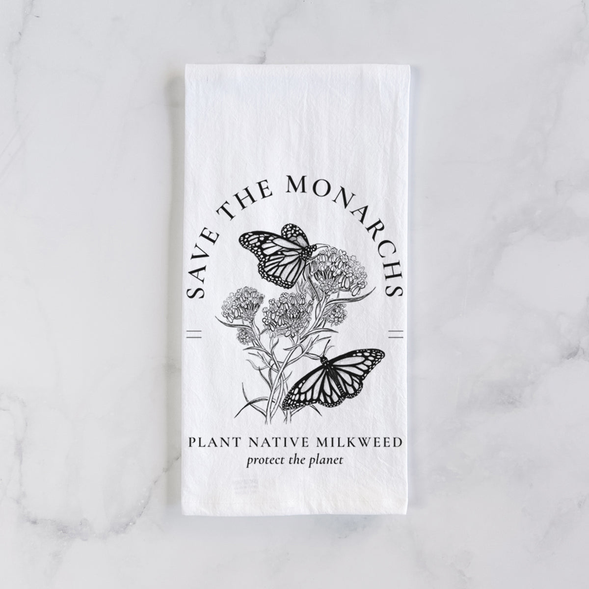 White cotton tea towel laid flat on marble, printed with black ink monarch butterflies on milkweed flowers, framed by the words Save the Monarchs, Plant Native Milkweed.