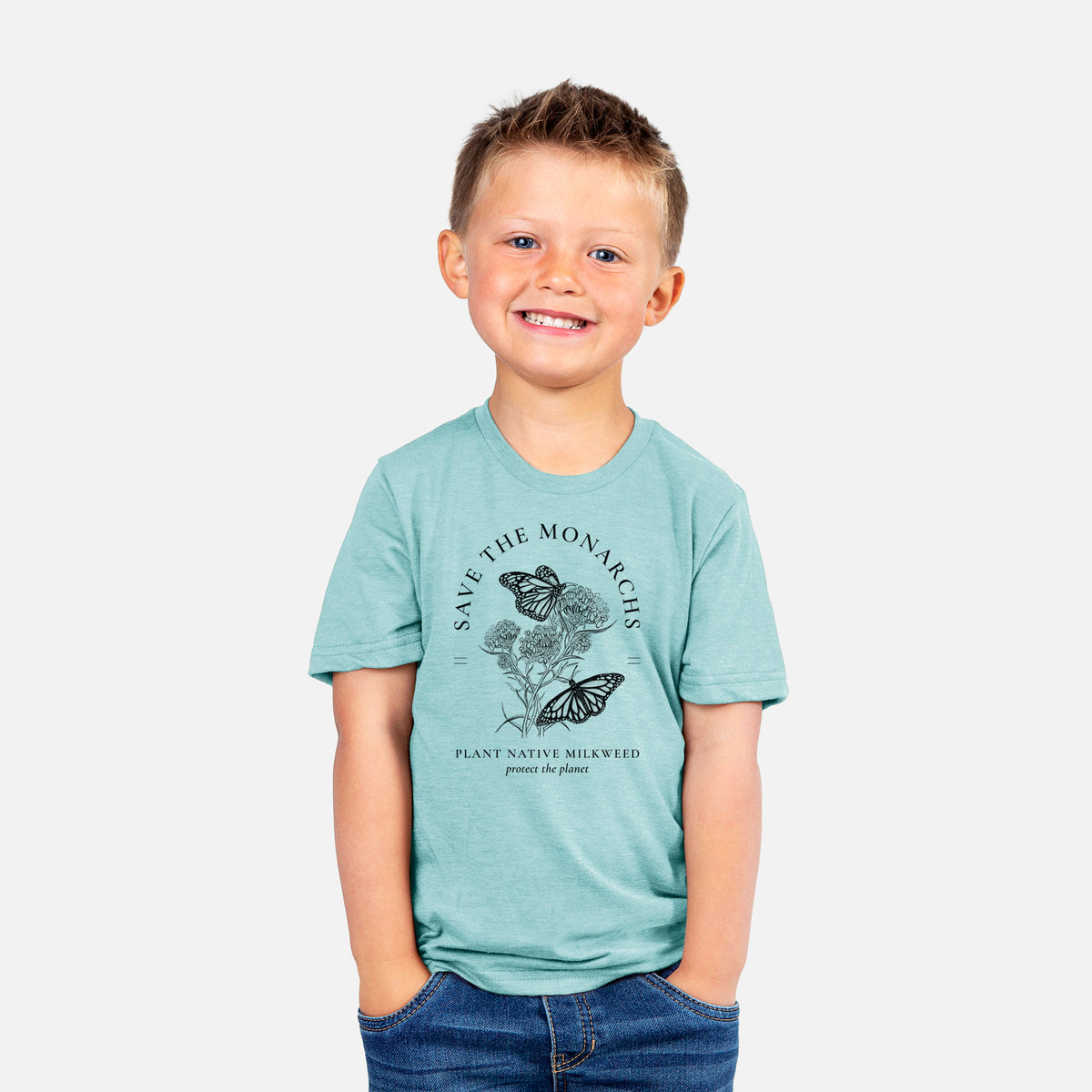 Smiling boy wearing a youth t-shirt printed with black ink monarch butterflies on milkweed flowers, framed by the words Save the Monarchs, Plant Native Milkweed.