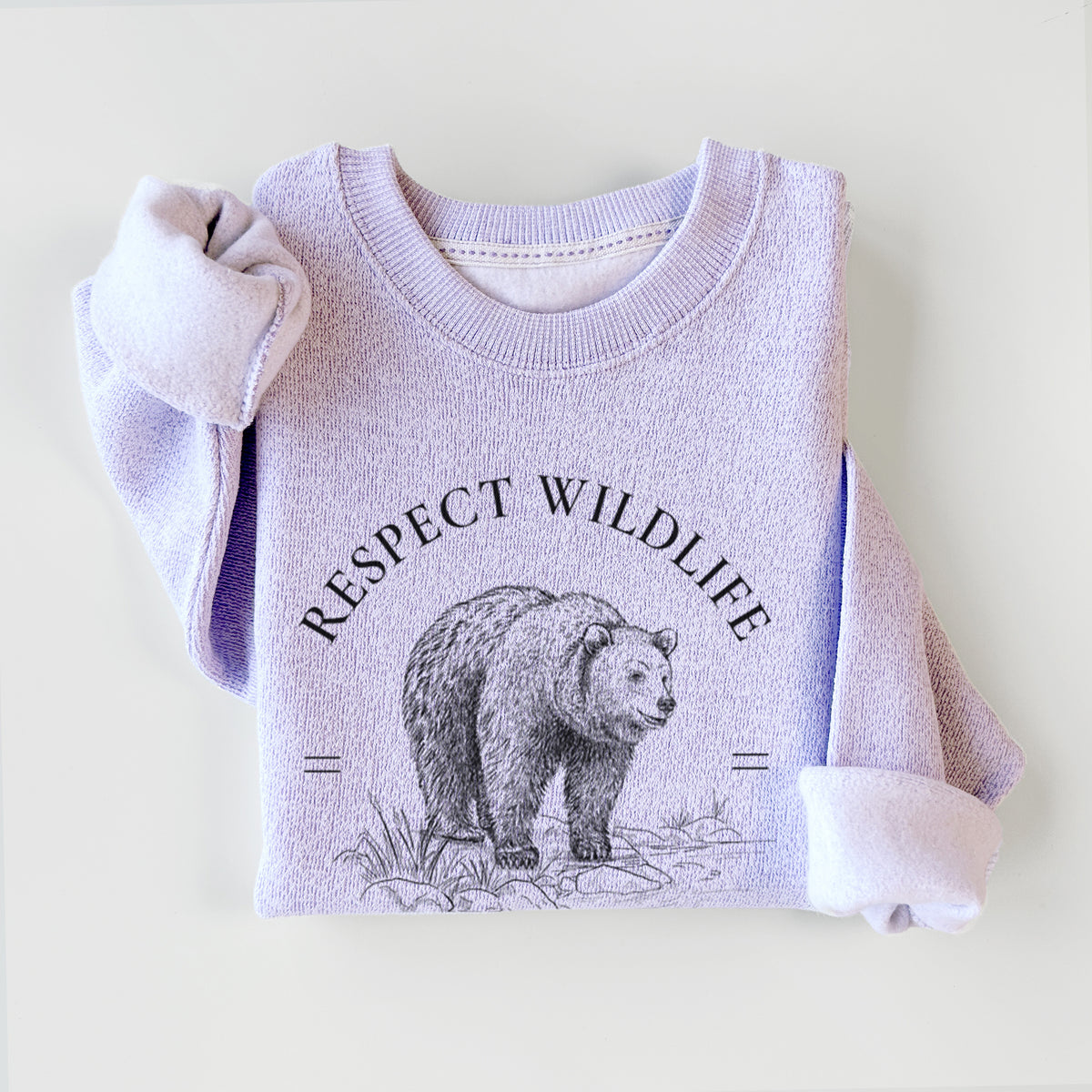 Ice purple knit sweatshirt printed with a black ink bear framed by the words Respect Wildlife, Keep the Wilderness Wild, styled flat.