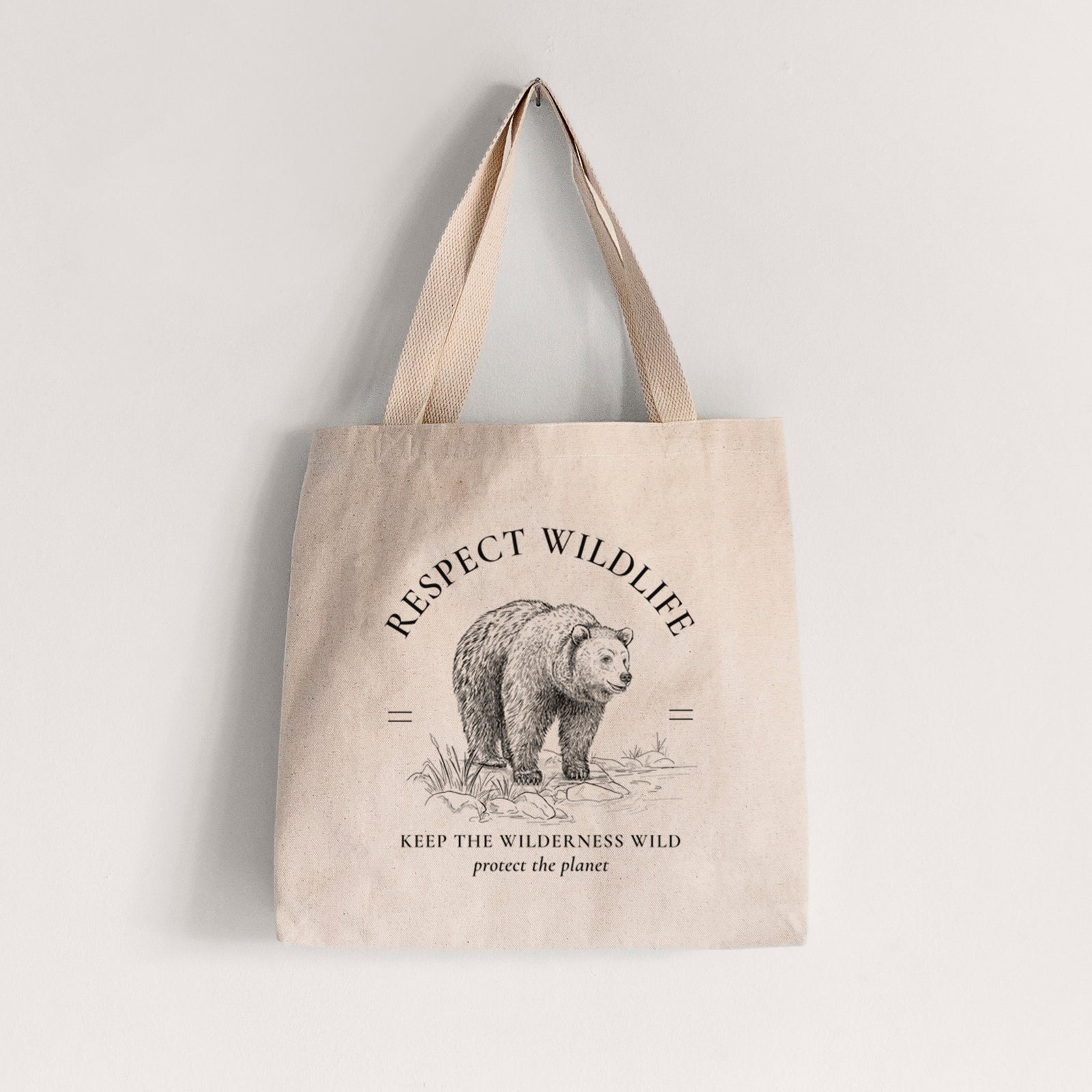 Natural canvas tote bag printed with a black ink bear framed by the words Respect Wildlife, Keep the Wilderness Wild.