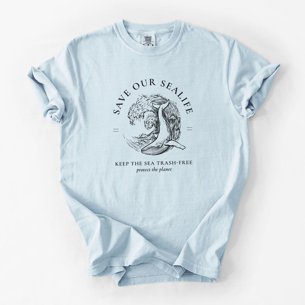 Chambray blue Comfort Colors t-shirt laid flat, printed with a black ink whale in an ocean wave framed by the words Save Our Sealife, Keep the Sea Trash-Free.