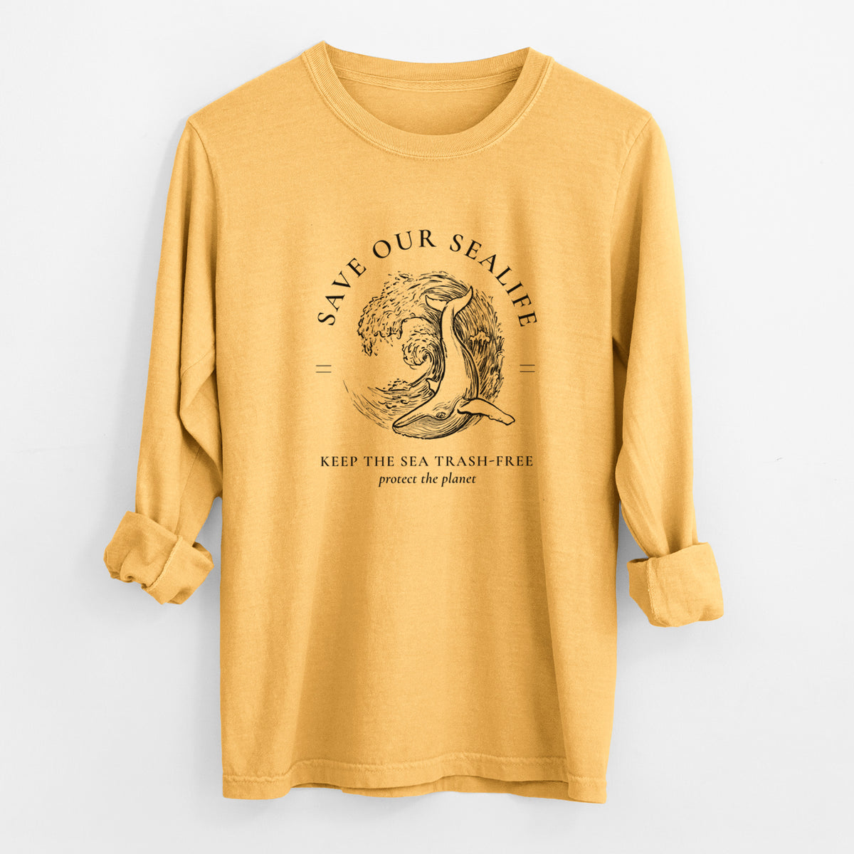 Golden wheat yellow Comfort Colors long sleeve shirt laid flat with the cuffs rolled, printed with a black ink whale in an ocean wave framed by the words Save Our Sealife, Keep the Sea Trash-Free.
