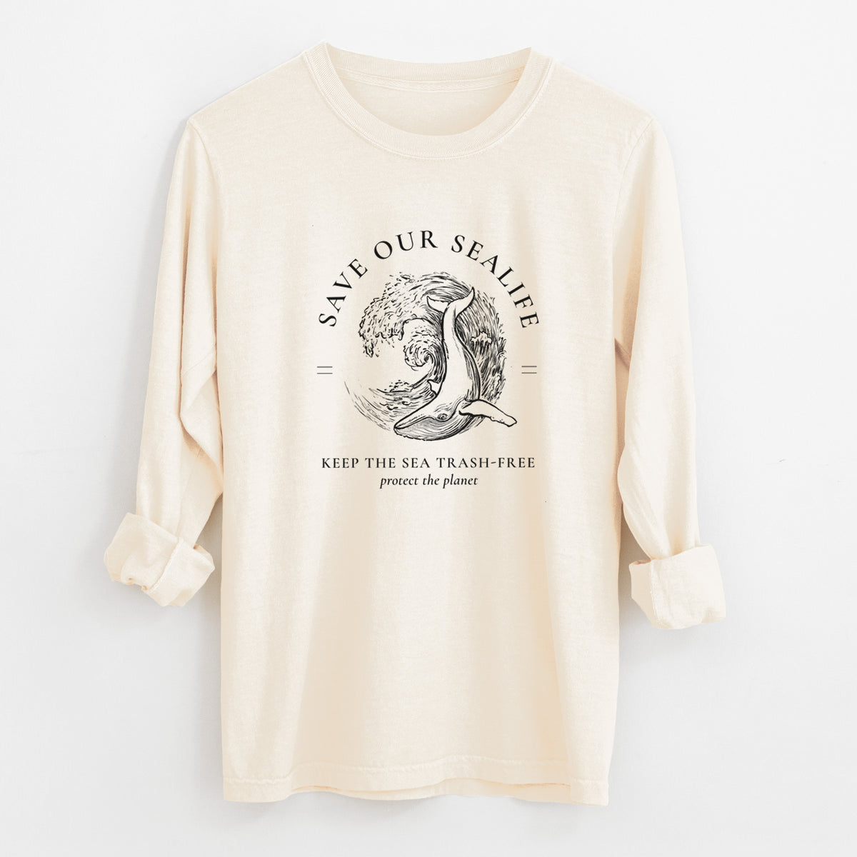 Ivory Comfort Colors long sleeve shirt laid flat with the cuffs rolled, printed with a black ink whale in an ocean wave framed by the words Save Our Sealife, Keep the Sea Trash-Free.