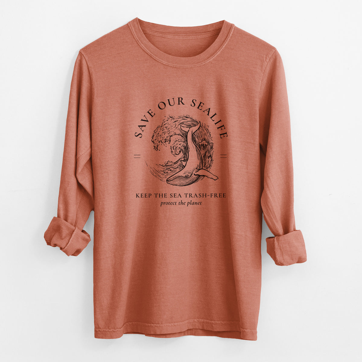 Yam burnt orange Comfort Colors long sleeve shirt laid flat with the cuffs rolled, printed with a black ink whale in an ocean wave framed by the words Save Our Sealife, Keep the Sea Trash-Free.