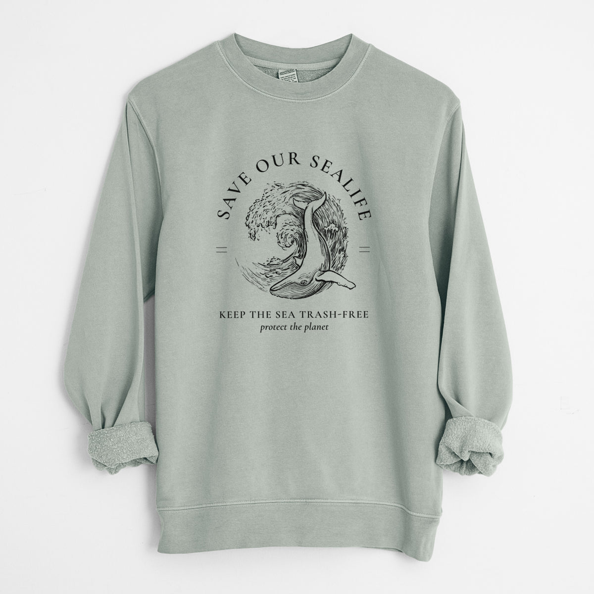 Sage green pigment dyed crewneck sweatshirt laid flat with the sleeves rolled, printed with a black ink whale in an ocean wave framed by the words Save Our Sealife, Keep the Sea Trash-Free.