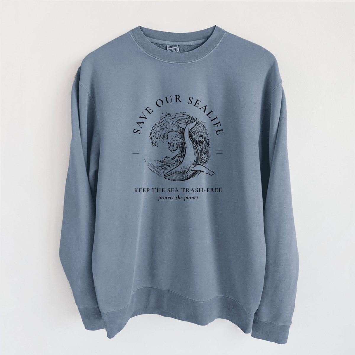 Slate blue pigment dyed crewneck sweatshirt laid flat, printed with a black ink whale in an ocean wave framed by the words Save Our Sealife, Keep the Sea Trash-Free.