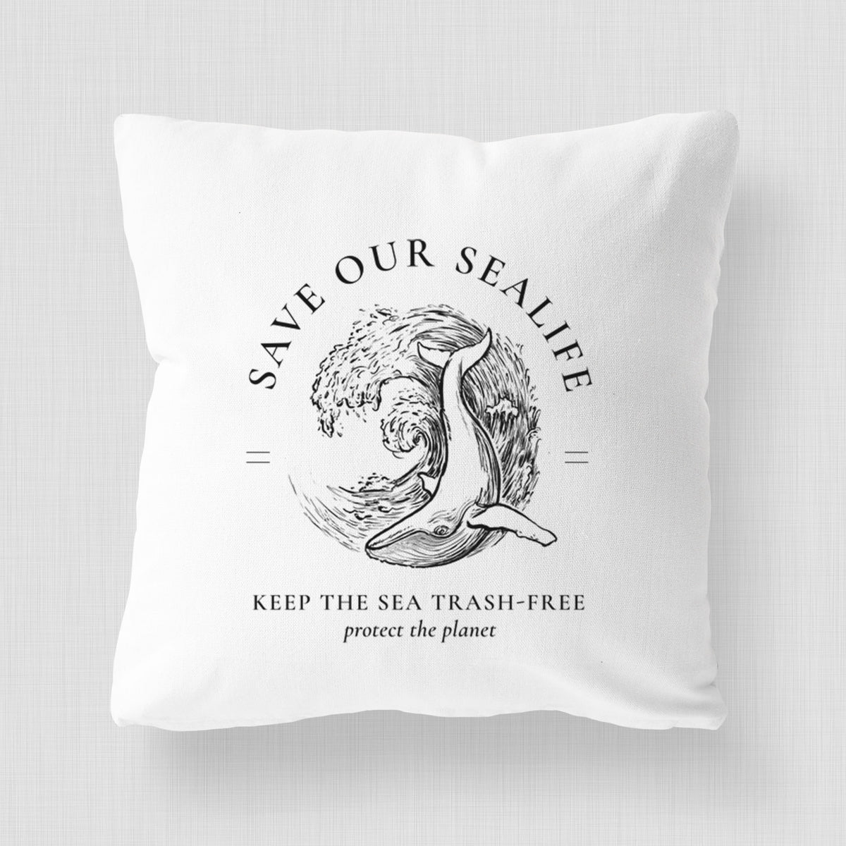 White pillow cover printed with a black ink whale in an ocean wave framed by the words Save Our Sealife, Keep the Sea Trash-Free.
