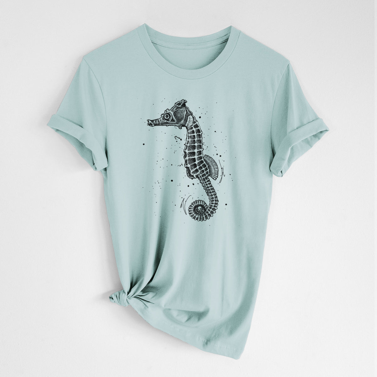 Dusty blue lightweight cotton t-shirt laid flat with the sleeves rolled, printed with a detailed black ink illustration of a Pacific seahorse with its tail curled.