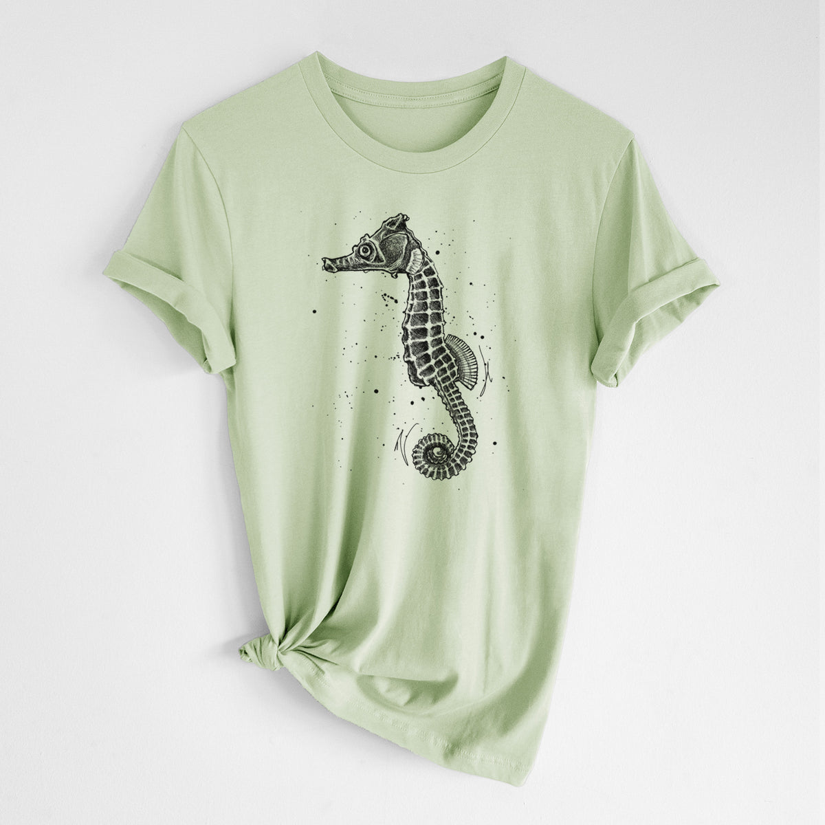 Spring green lightweight cotton t-shirt laid flat with the sleeves rolled, printed with a detailed black ink illustration of a Pacific seahorse with its tail curled.