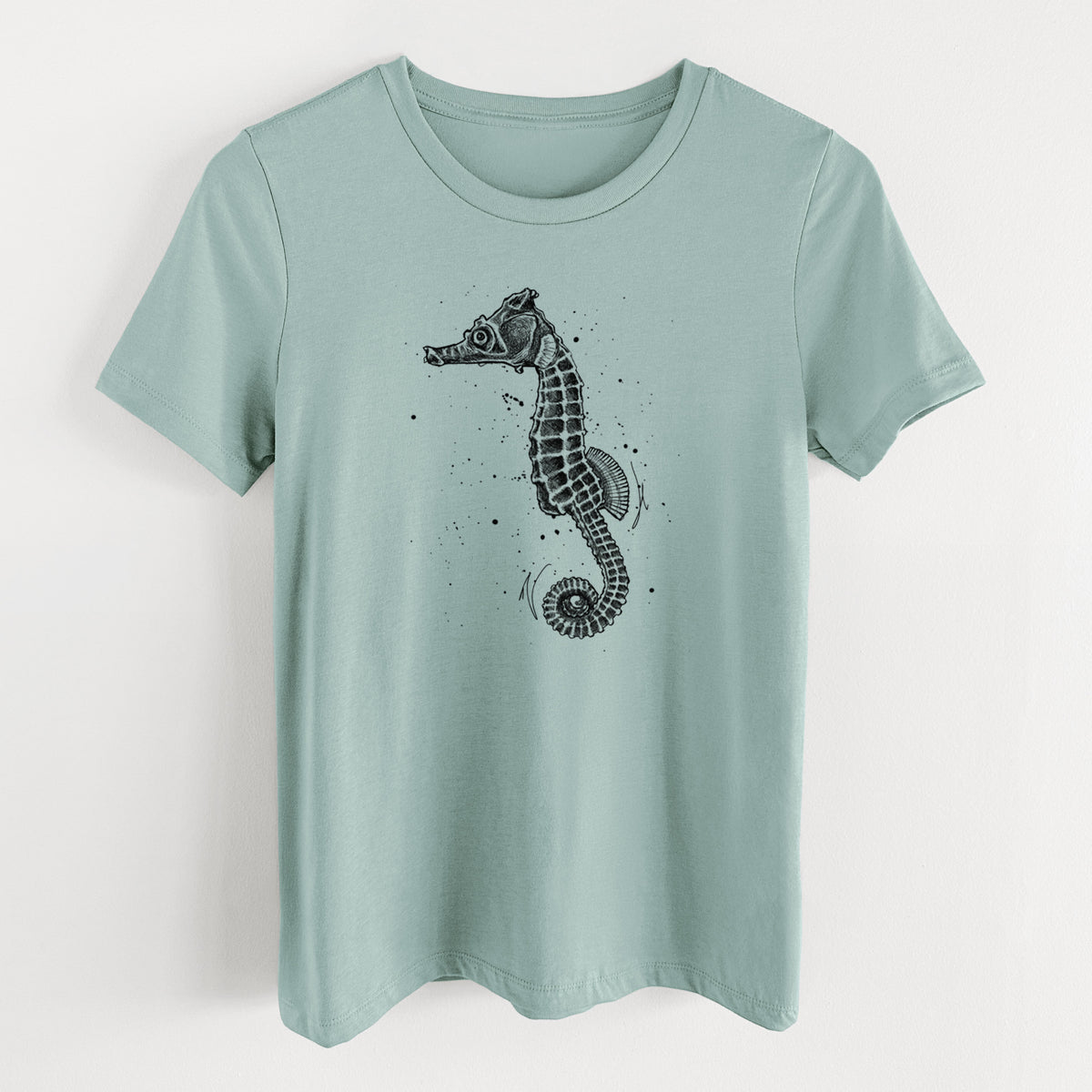 Dusty blue women's relaxed fit cotton t-shirt laid flat, printed with a detailed black ink illustration of a Pacific seahorse with its tail curled.