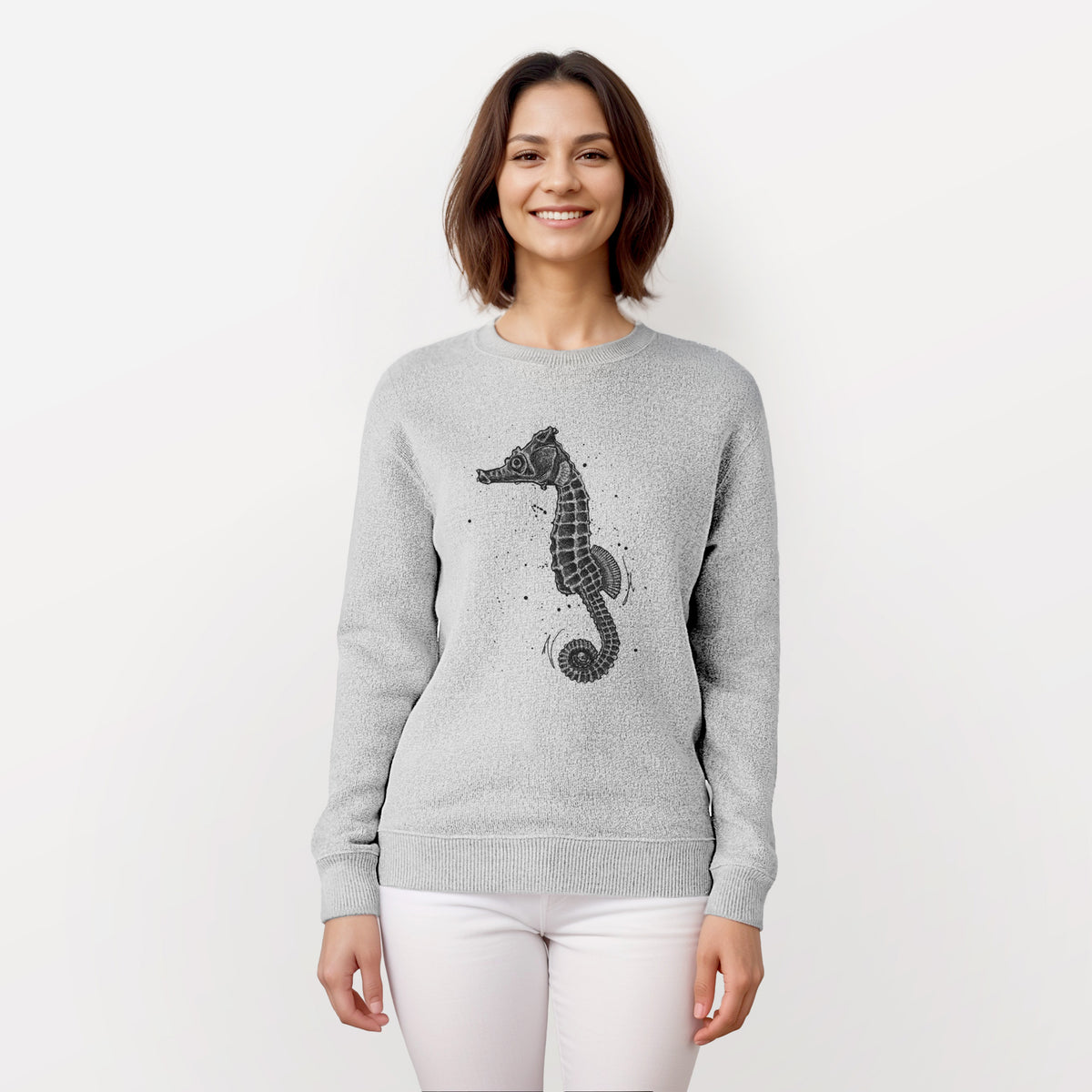 Woman wearing a knit sweatshirt printed with a detailed black ink illustration of a Pacific seahorse with its tail curled.