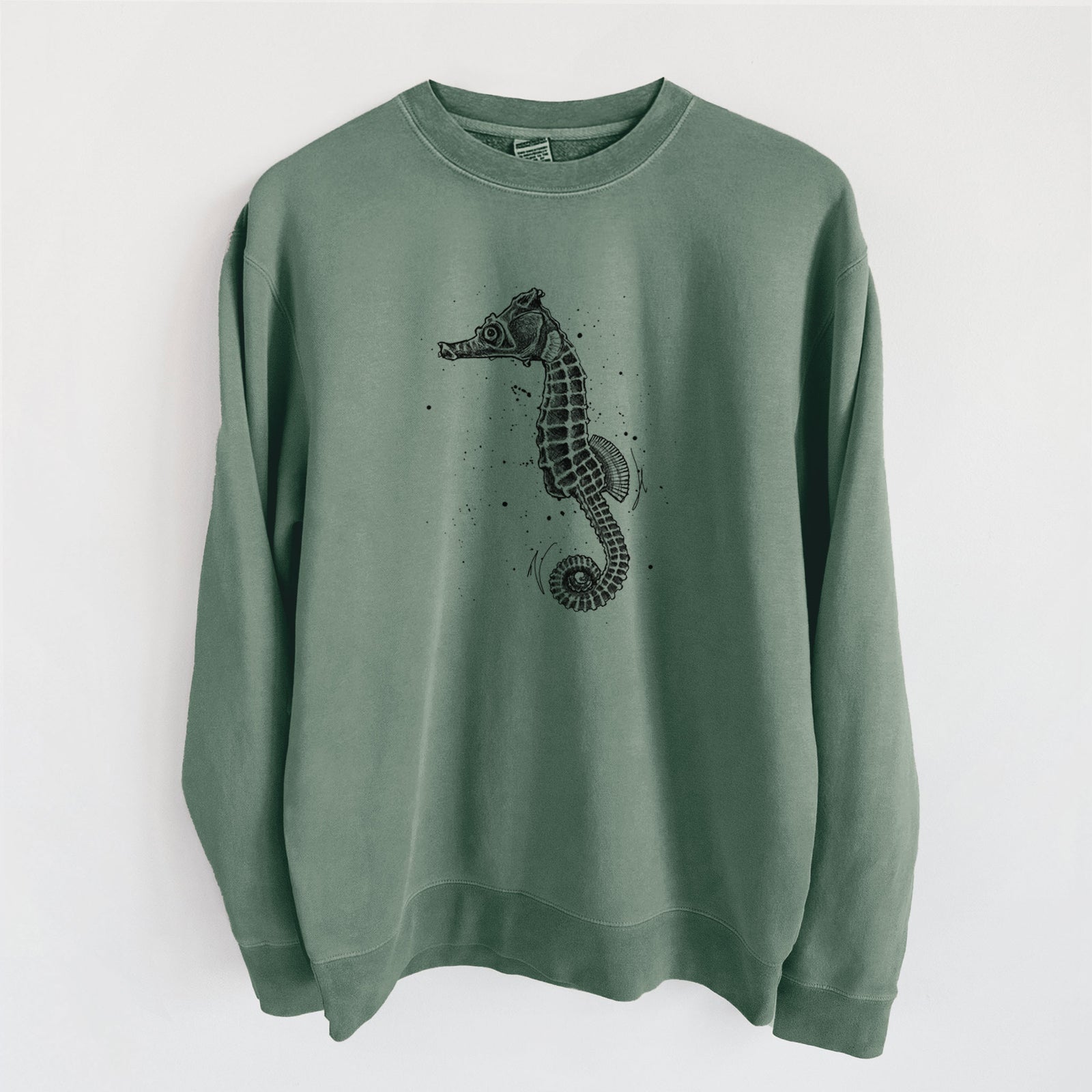 Alpine green pigment dyed crewneck sweatshirt laid flat, printed with a detailed black ink illustration of a Pacific seahorse with its tail curled.