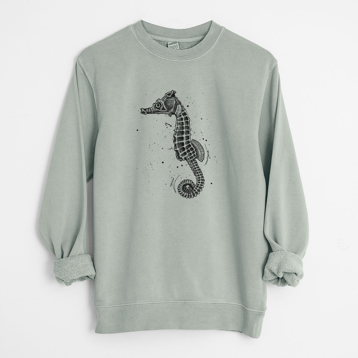 Sage green pigment dyed crewneck sweatshirt laid flat with the sleeves rolled, printed with a detailed black ink illustration of a Pacific seahorse with its tail curled.