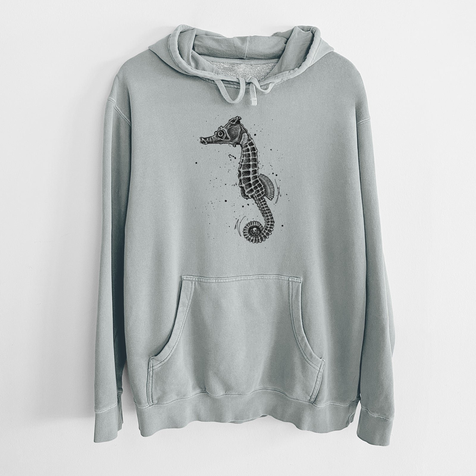 Sage green pigment dyed hoodie laid flat, printed with a detailed black ink illustration of a Pacific seahorse with its tail curled.